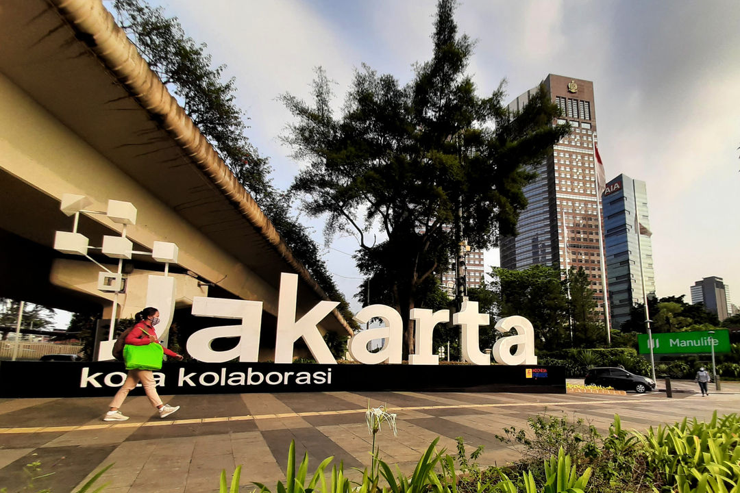 Warga melintas di dekat tulisan Jakarta Kota Kolaborasi di kawasan Jalan Sudirman, Jakarta, Senin, 2 Agustus 2021. Foto: Ismail Pohan/TrenAsia