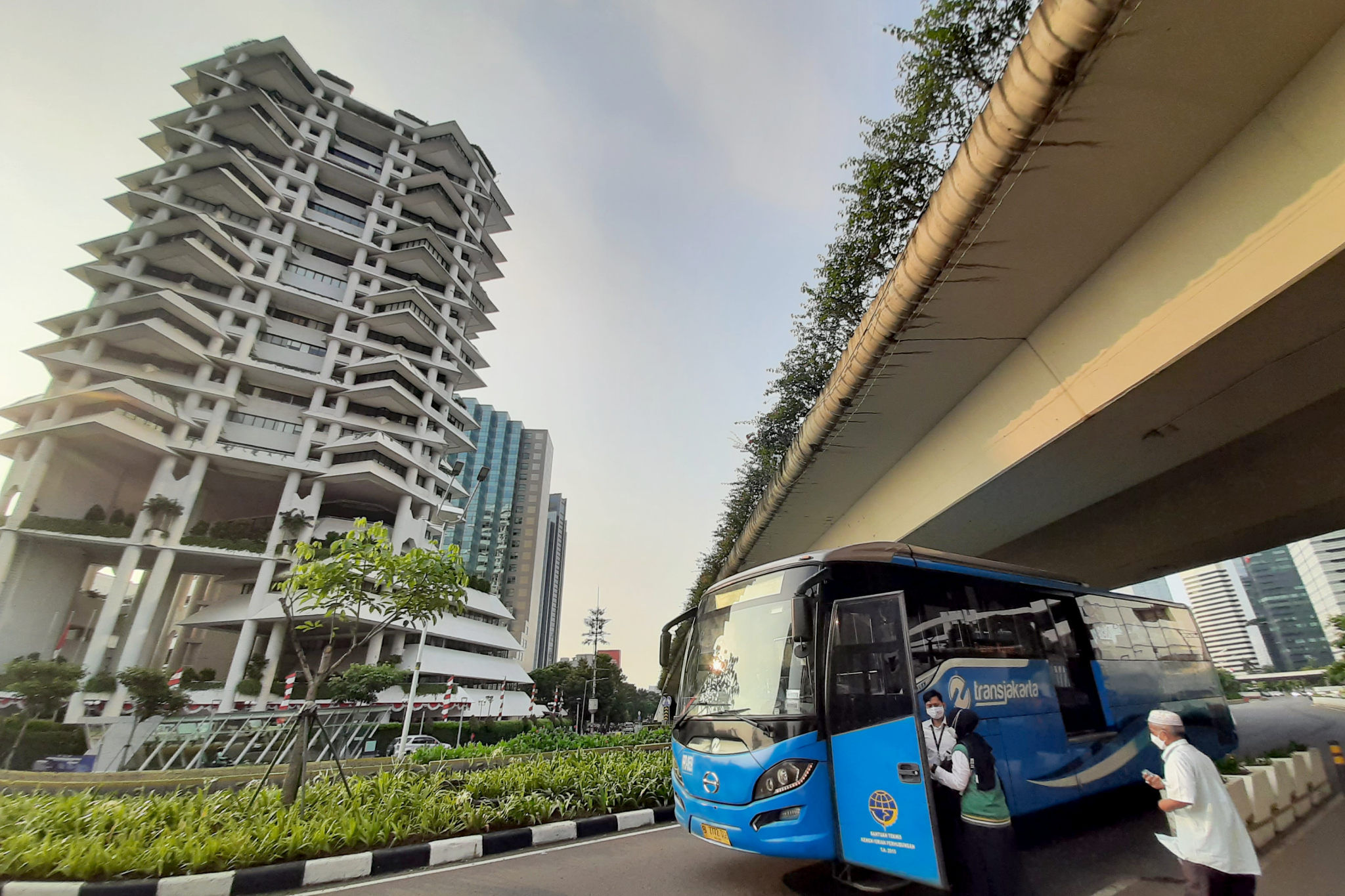 Warga bersiap menaiki transportasi umum di kawasan Jalan Sudirman, Jakarta, Senin, 2 Agustus 2021. Foto: Ismail Pohan/TrenAsia