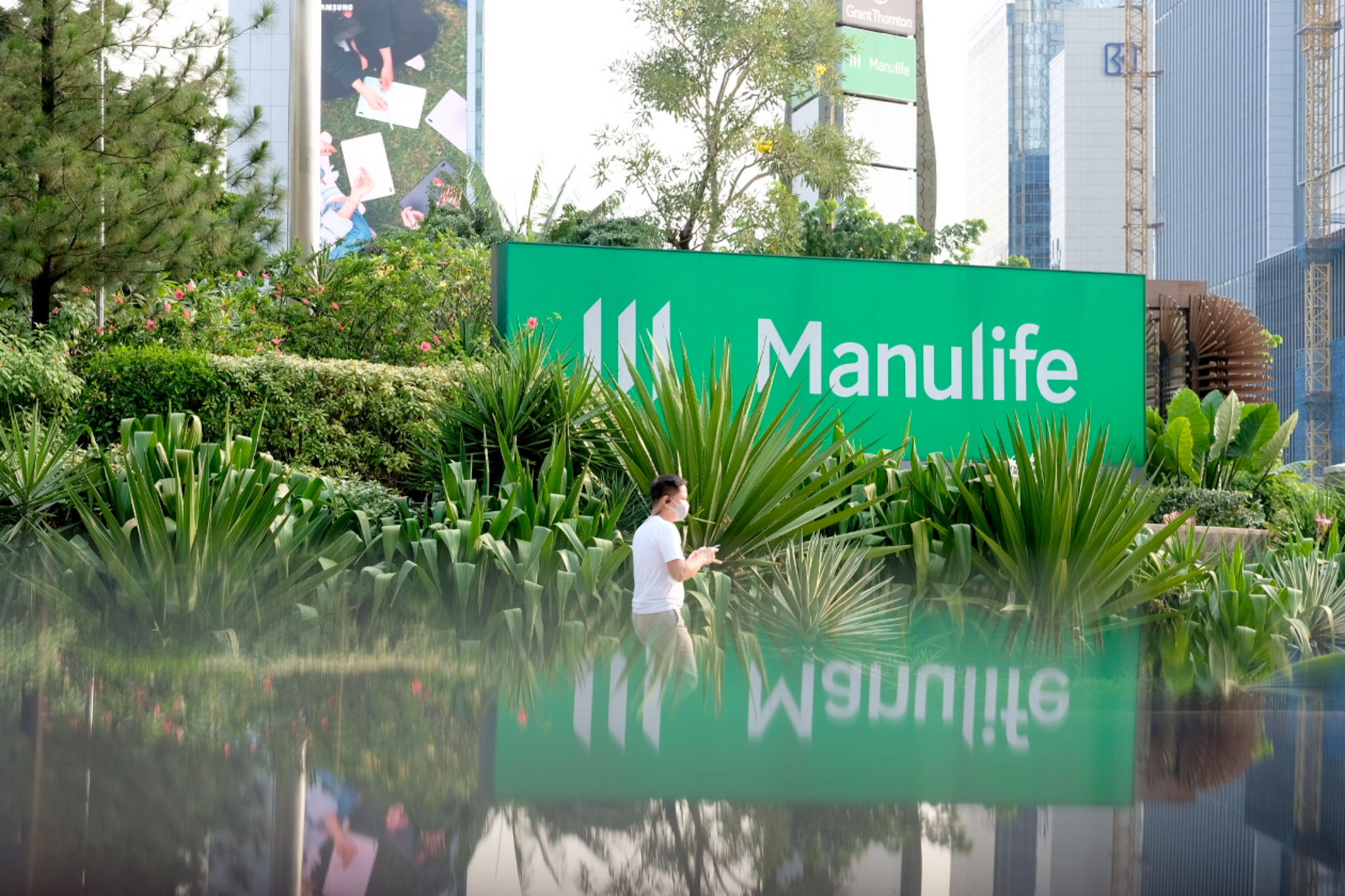 Warga melintas di dekat logo asuransi jiwa Manulife kawasan Sudirman, Jakarta. Foto: Ismail Pohan/TrenAsia