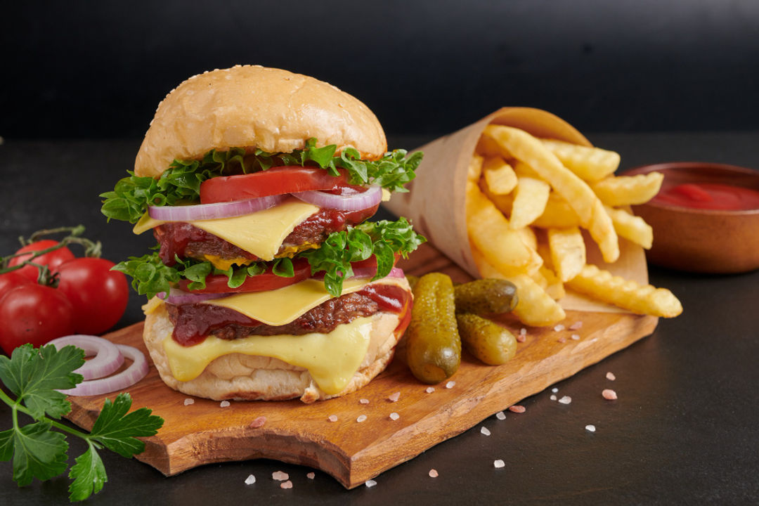 homemade-hamburger-burger-with-fresh-vegetables-cheese-lettuce-mayonnaise-served-french-fries-pieces-brown-paper-black-stone-table-concept-fast-food-junk-food.jpg