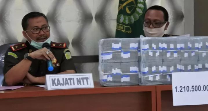 Kepala Kejaksaan Tinggi NTT Yulianto (kiri) saat menunjuk uang sitaan dari para terpidana kasus korupsi dana modal usaha fasilitas kredit pada Bank NTT Cabang Surabaya. 