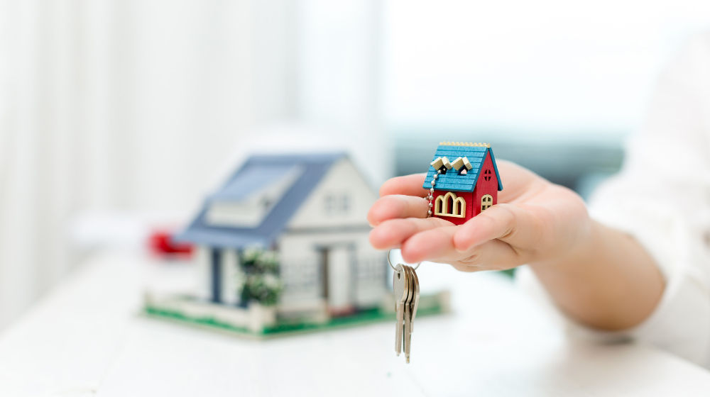 real-estate-agent-with-house-model-keys.jpg
