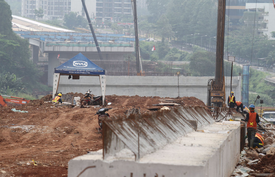 Sejumlah pekerja dengan alat berat tengah menyelesaikan proyek pembangunan Tol Serpong Balaraja di kawasan Cilenggang TangSel, Kamis 26 Agustus 2021. Foto : Panji Asmoro/TrenAsia