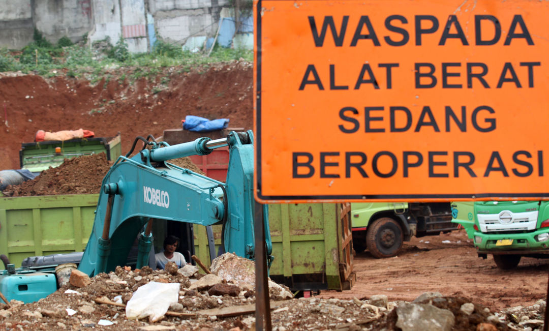 Sejumlah pekerja dengan alat berat tengah menyelesaikan proyek pembangunan Tol Serpong Balaraja di kawasan Cilenggang TangSel, Kamis 26 Agustus 2021. Foto : Panji Asmoro/TrenAsia