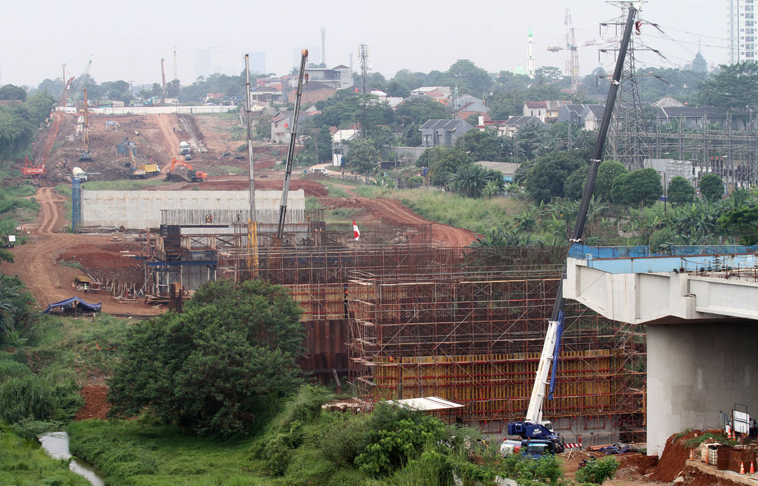 Sejumlah pekerja dengan alat berat tengah menyelesaikan proyek pembangunan Tol Serpong Balaraja di kawasan Cilenggang TangSel, Kamis 26 Agustus 2021. Foto : Panji Asmoro/TrenAsia