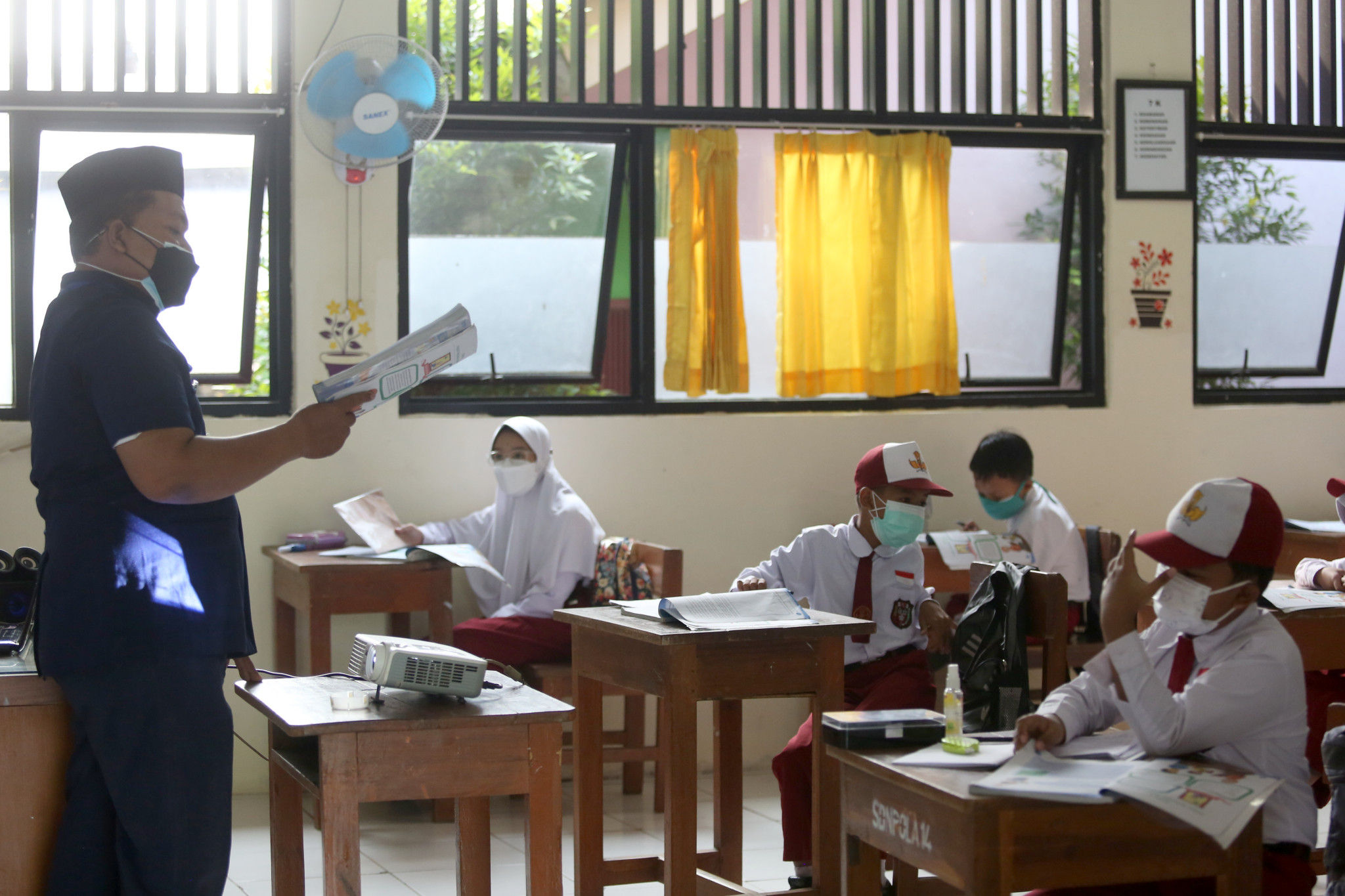Guru menyampaikan materi pelajaran kepada Siswa Sekolah Dasar yang mengikuti Sekolah Tatap Muka Perdana di SDN 14 Pagi, Pondok Labu, Jakarta Selatan, Senin, 30 Agustus 2021. Foto: Ismail Pohan/TrenAsia