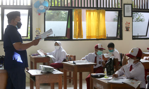 Guru menyampaikan materi pelajaran kepada Siswa Sekolah Dasar yang mengikuti Sekolah Tatap Muka Perdana di SDN 14 Pagi, Pondok Labu, Jakarta Selatan, Senin, 30 Agustus 2021. Foto: Ismail Pohan/TrenAsia