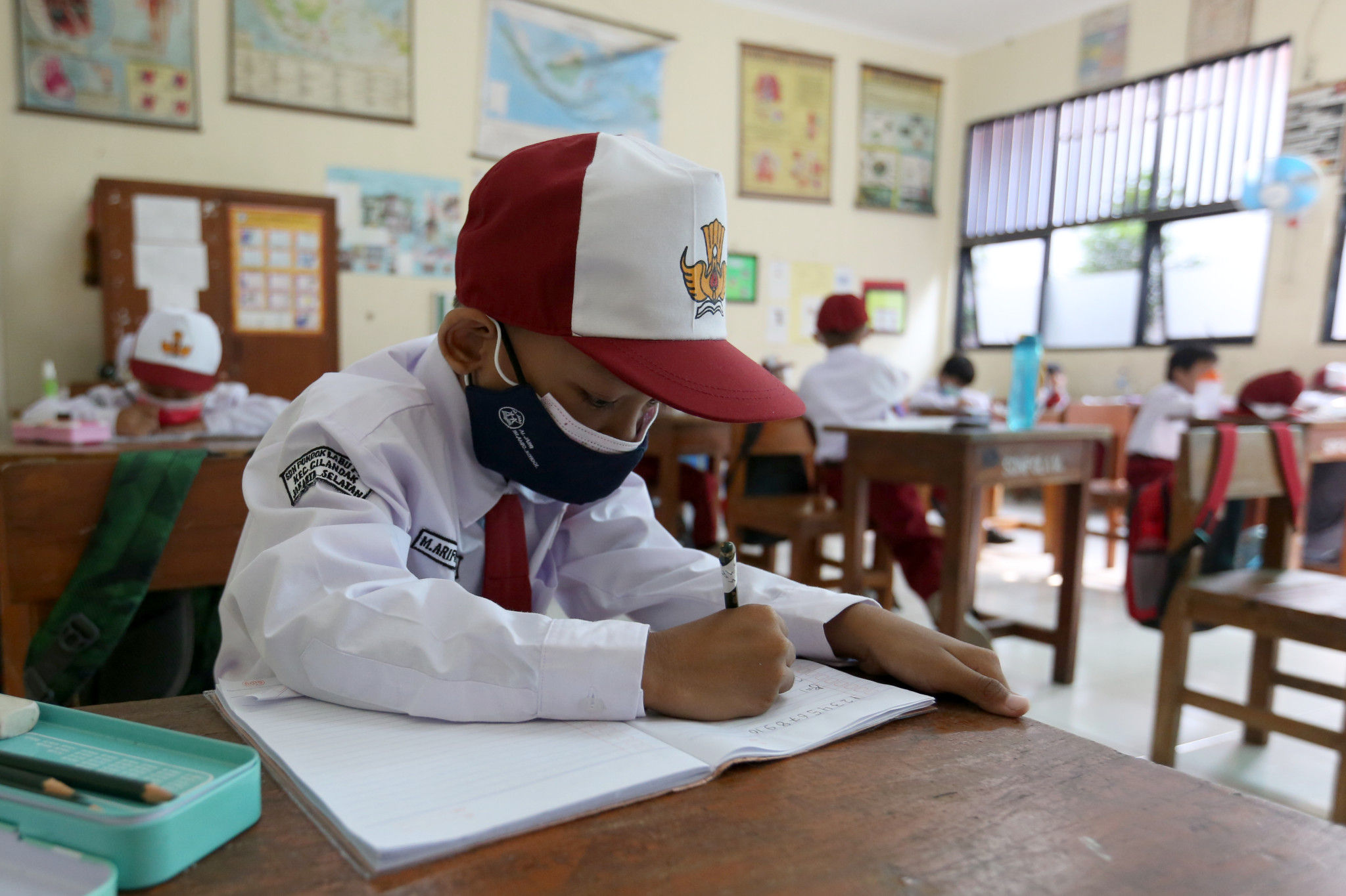 Siswa Sekolah Dasar serius mengikuti Sekolah Tatap Muka Perdana di SDN 14 Pagi, Pondok Labu, Jakarta Selatan, Senin, 30 Agustus 2021. Foto: Ismail Pohan/TrenAsia