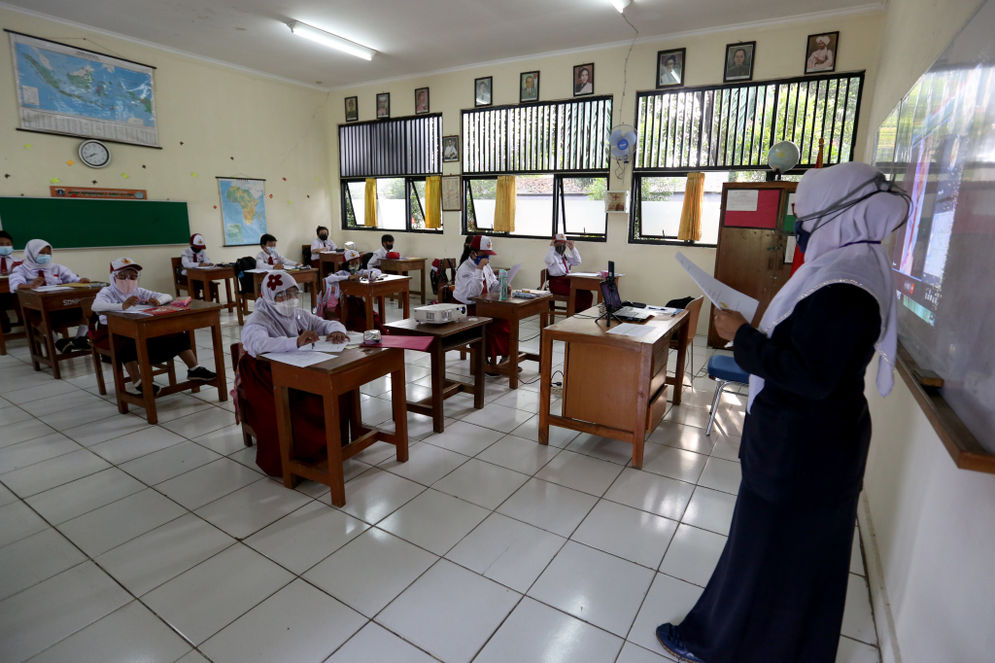 Guru memberikan materi pelajaran kepada siswa yang mengikuti Sekolah Tatap Muka Perdana di SDN 14 Pagi, Pondok Labu, Jakarta Selatan, Senin, 30 Agustus 2021.