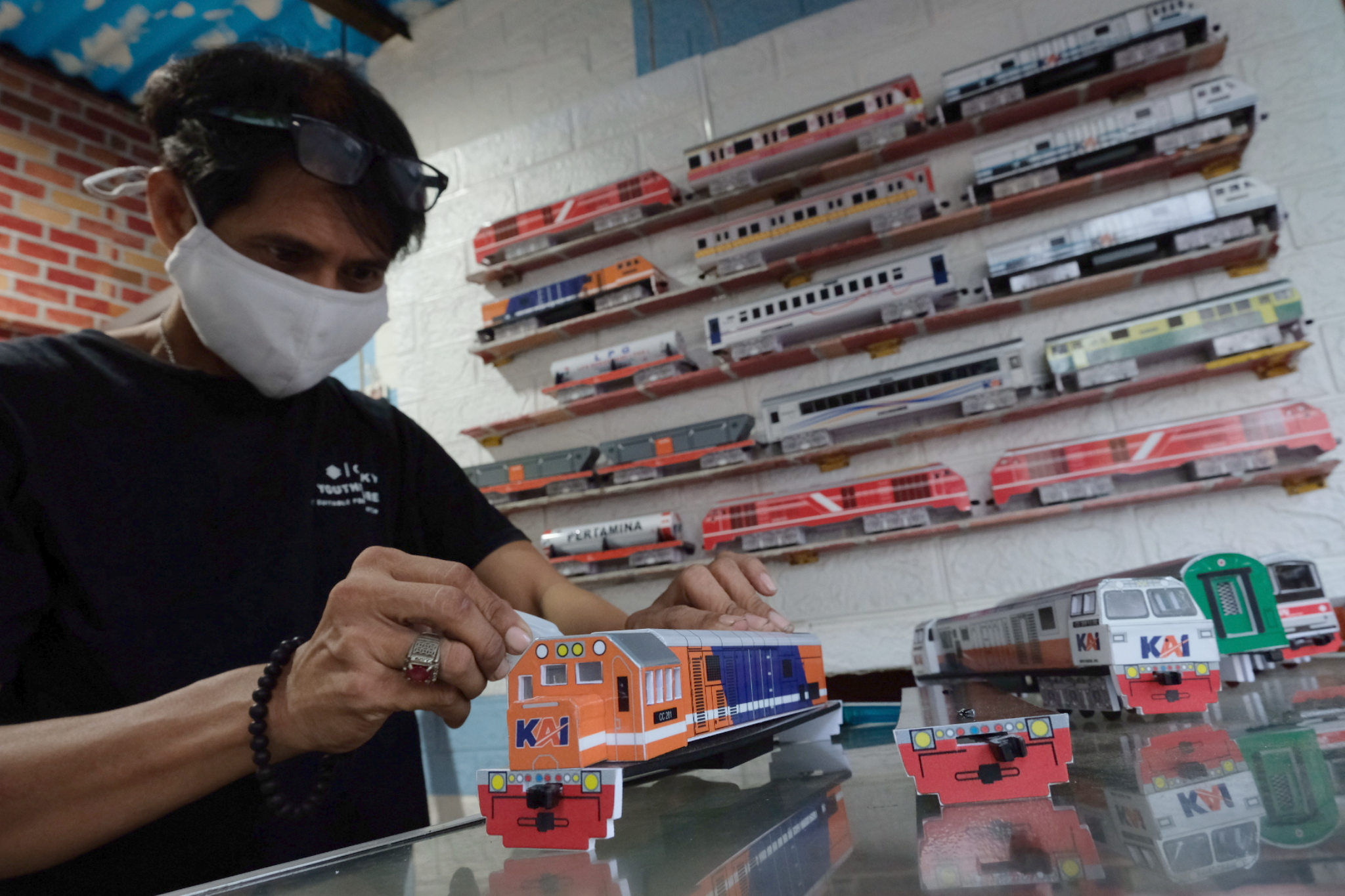 Pengrajin menyelesaikan pembuatan miniatur gerbong kereta api di kiosnya di kawasan Manggarai, Rabu, 1 September 2021. Foto: Ismail Pohan/TrenAsia