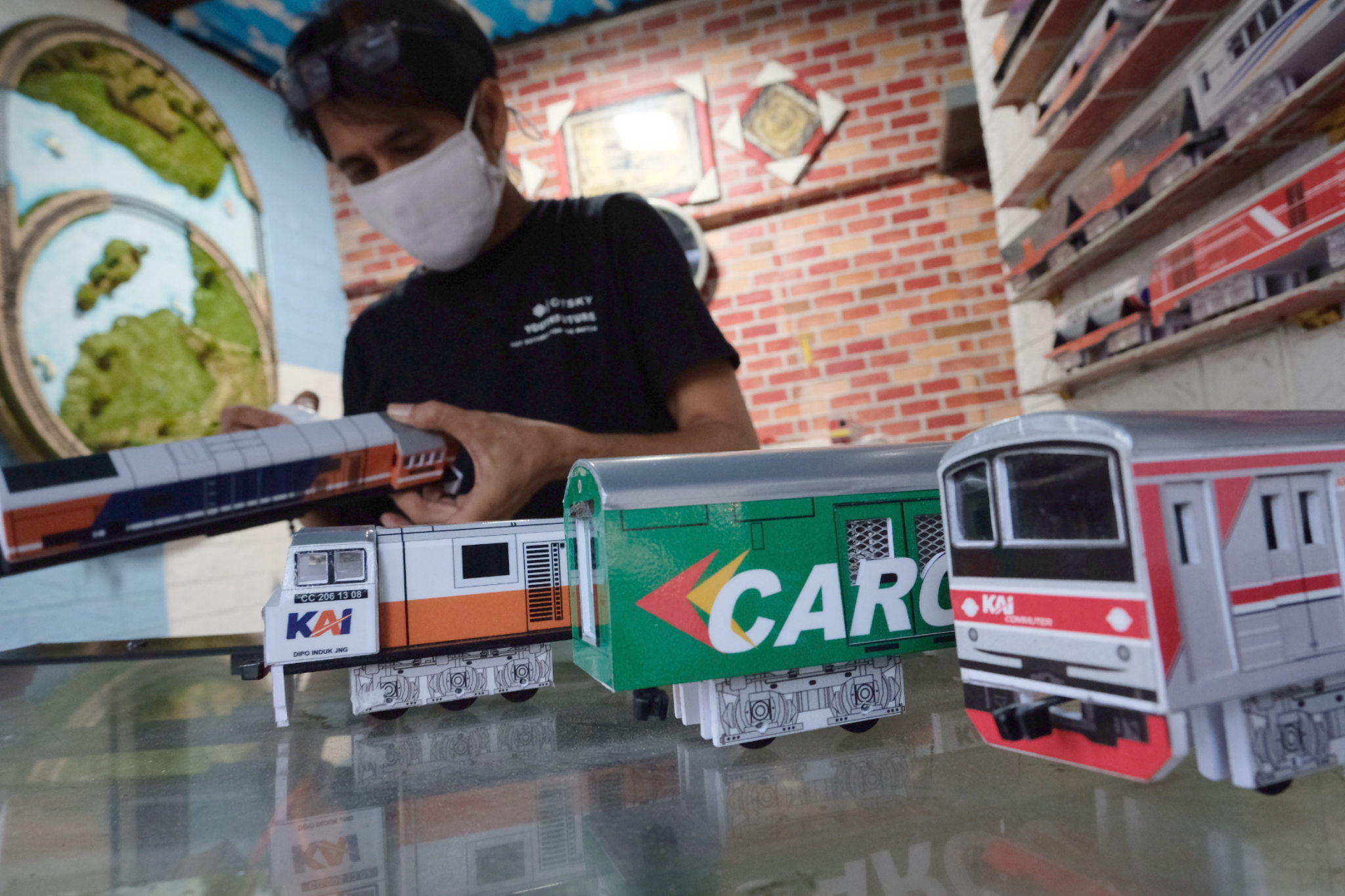 Pengrajin menyelesaikan pembuatan miniatur gerbong kereta api di kiosnya di kawasan Manggarai, Rabu, 1 September 2021. Foto: Ismail Pohan/TrenAsia
