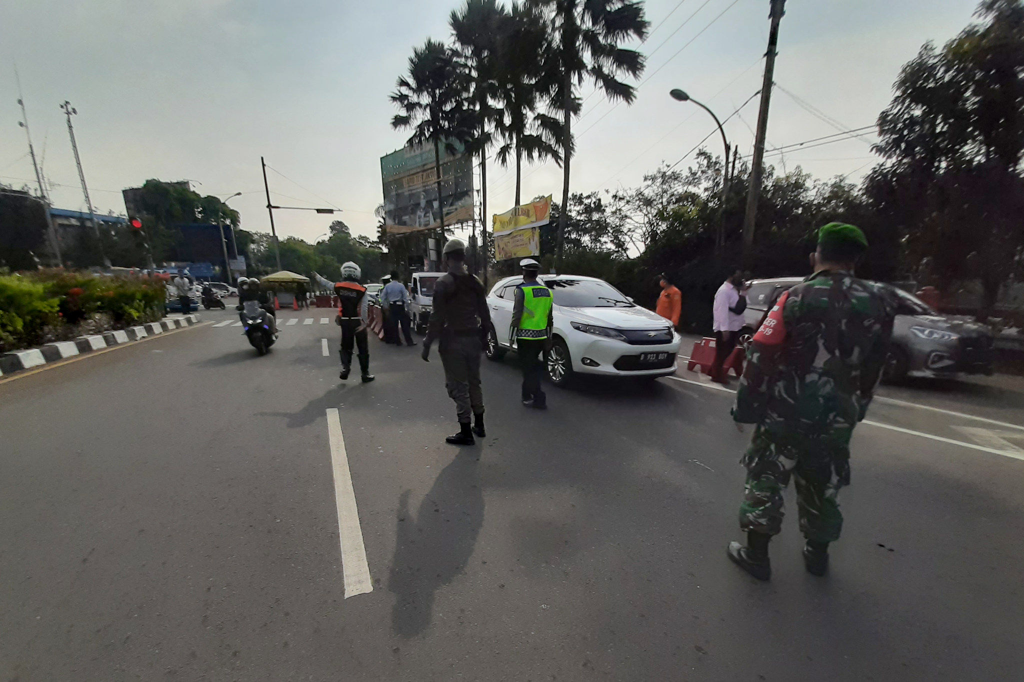 Petugas gabungan mengarahkan kendaraan saat uji coba penerapan sistem ganjil genap di Jalan Raya Puncak, Gadog, Ciawi, Kabupaten Bogor, Jawa Barat, Jumat, 3 September 2021. Foto: Ismail Pohan/TrenAsia
