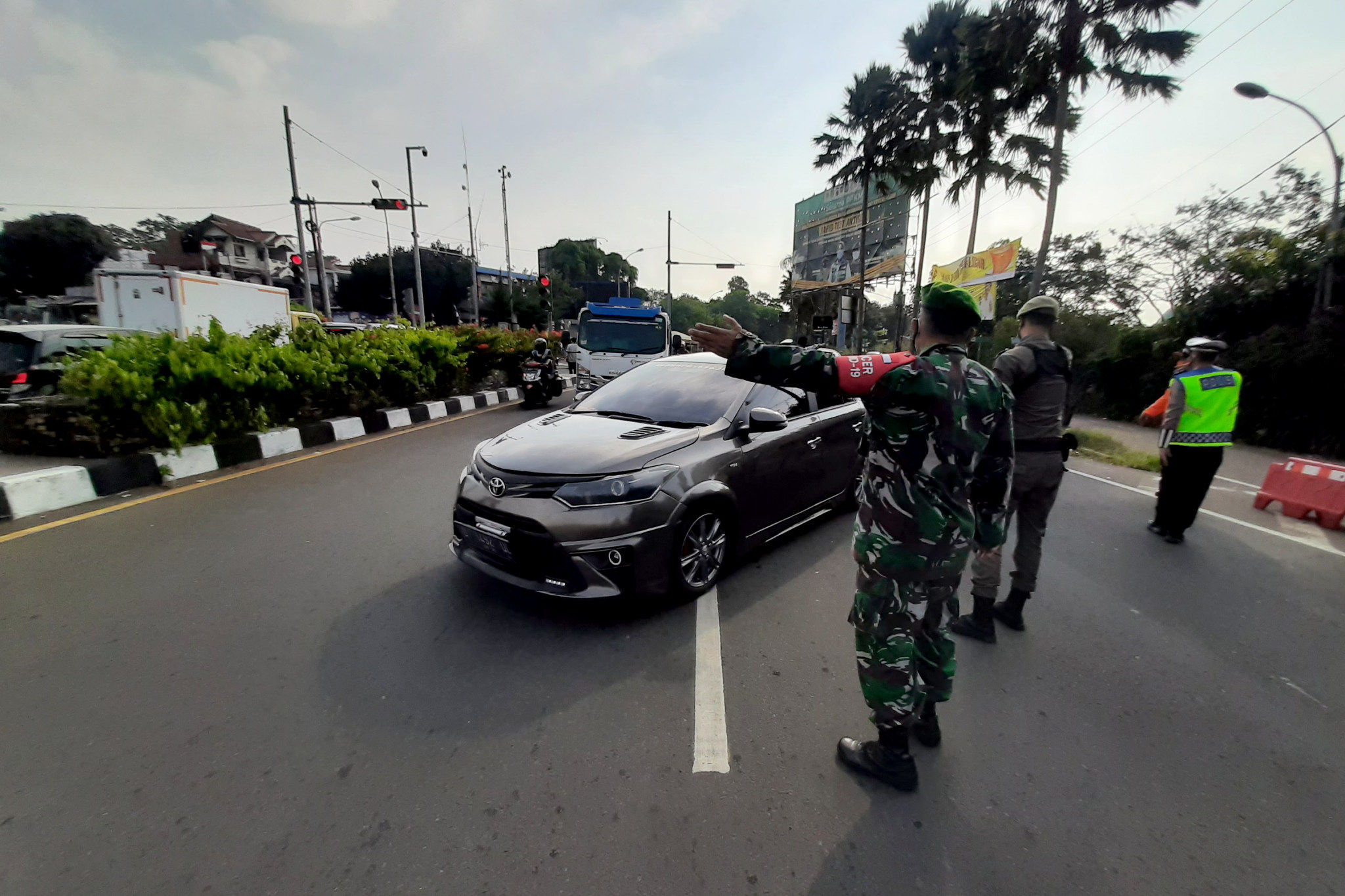 Petugas gabungan mengarahkan kendaraan saat uji coba penerapan sistem ganjil genap di Jalan Raya Puncak, Gadog, Ciawi, Kabupaten Bogor, Jawa Barat, Jumat, 3 September 2021. Foto: Ismail Pohan/TrenAsia