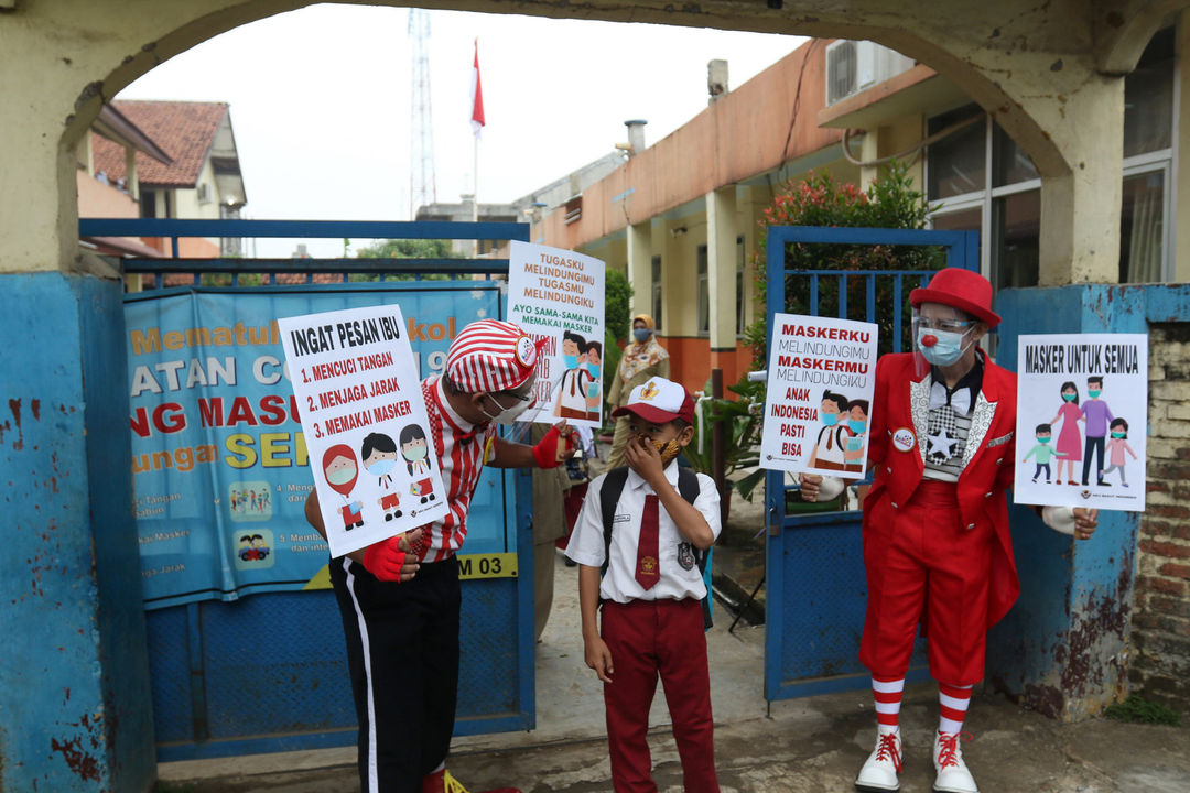 Anggota Aku Badut Indonesia (ABI) membawa poster melakukan kampanye protokol kesehatan 3M untuk siswa yang mengikuti pembelajaran tatap muka (PTM) di SDN 03 Citayam, Kabupaten Bogor, Jawa Barat, Senin, 6 September 2021. Foto: Ismail Pohan/TrenAsia