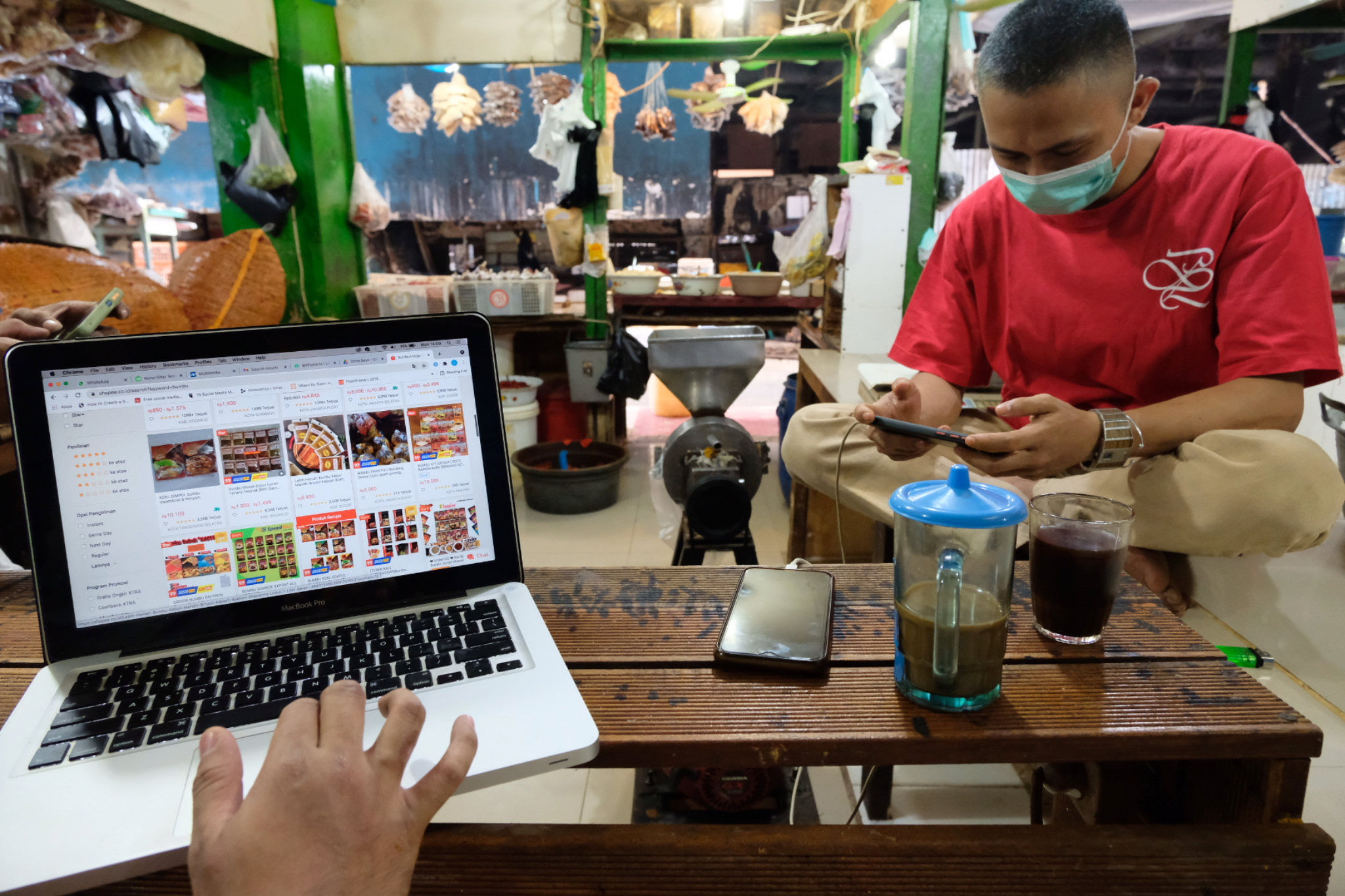 Pedagang mengoperasikan gawai di salah kios pasar tradisional kawasan Pasar Minggu, Jakarta, Selasa, 7 September 2021. Foto: Ismail Pohan/TrenAsia