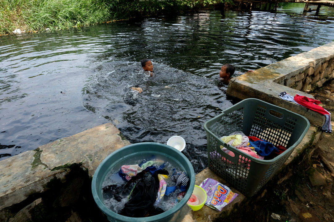 Sejumlah anak bermain di kali yang berwana hitam dan berbau tak sedap di Desa Sukaraya, Karangbahagia, Kabupaten Bekasi, Jawa Barat, Selasa, 7 November 2021. Foto: Ismail Pohan/TrenAsia