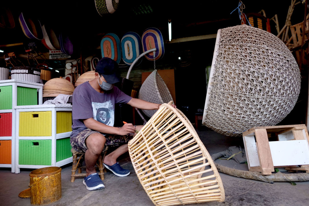 Pekerja menyelesaikan pembuatan produk di kios sentra kerajinan berbahan rotan di kawasan Pondok Gede, Jakarta Timur, Senin, 13 September 2021. Foto: Ismail Pohan/TrenAsia