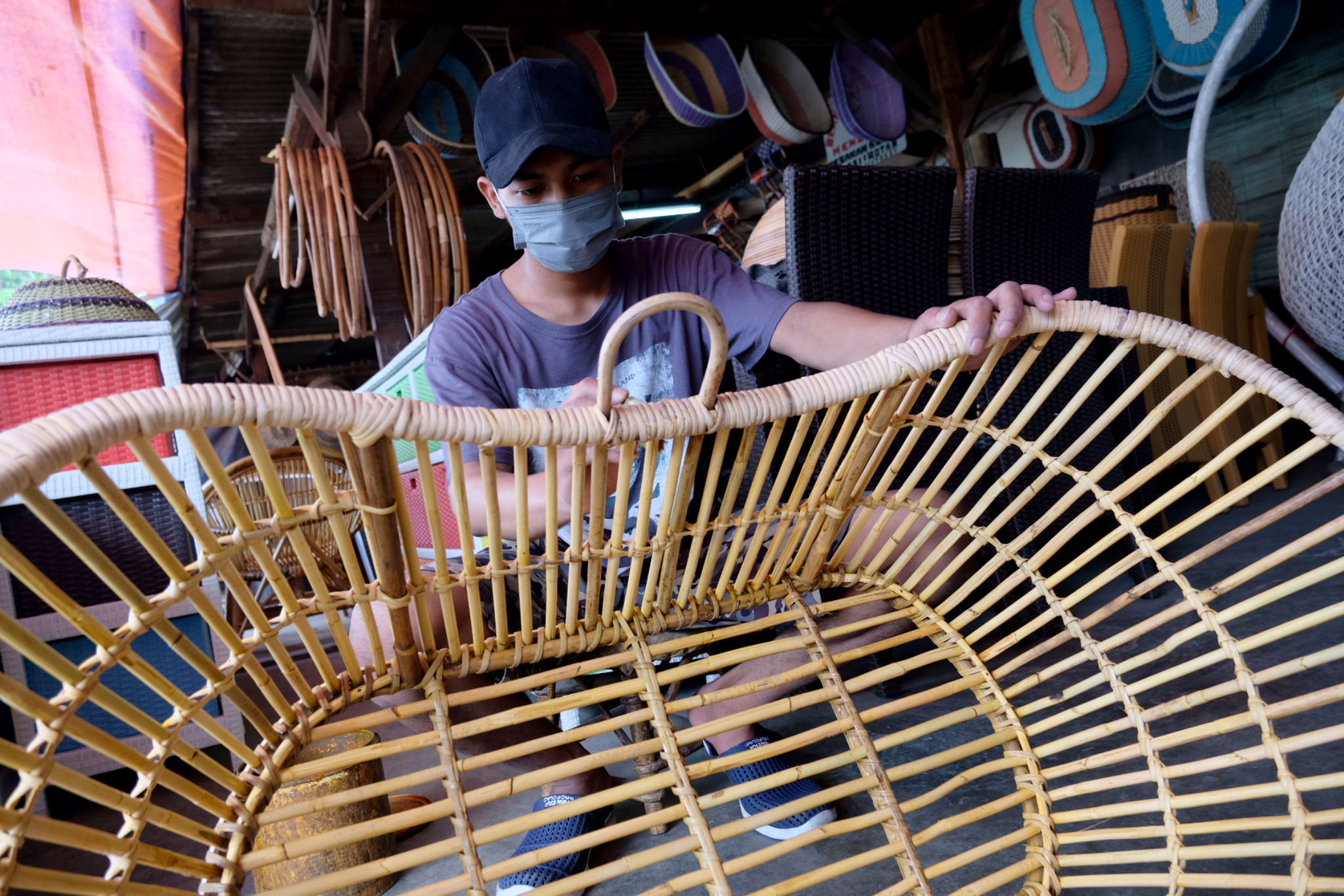 Pekerja menyelesaikan pembuatan produk di kios sentra kerajinan berbahan rotan di kawasan Pondok Gede, Jakarta Timur, Senin, 13 September 2021. Foto: Ismail Pohan/TrenAsia