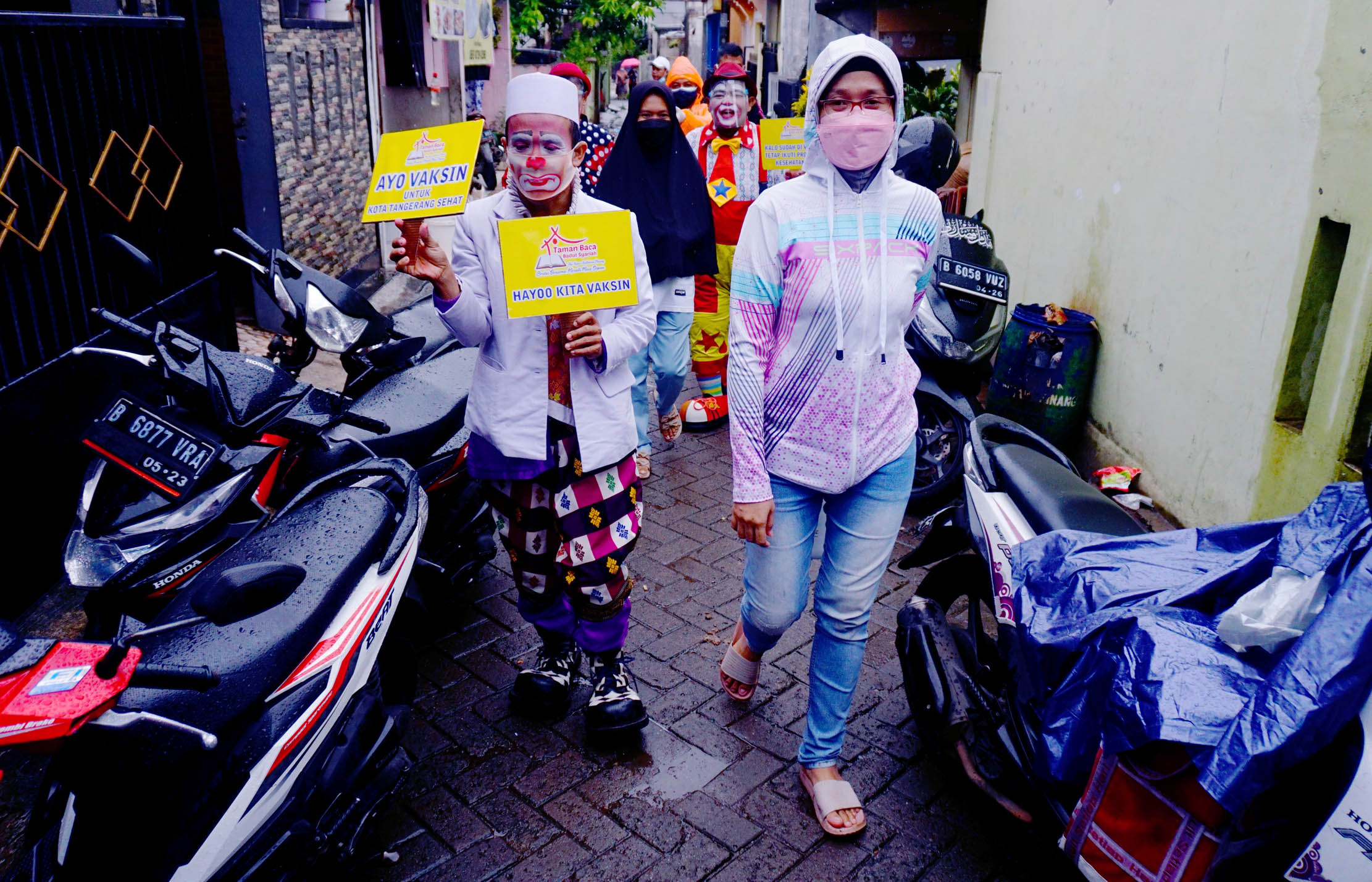 Badut Yahya dan kawan-kawan ikut serta mengkampanyekan dan ajakan kepada warga untuk melakukan vaksin, para badut tersebut berkeliling dari rumah-kerumah untuk menjemput warga yang akan di vaksin di kawasan Pinang Kota Tangerang, Selasa 14 September 2021. Foto : Panji Asmoro/TrenAsia                           