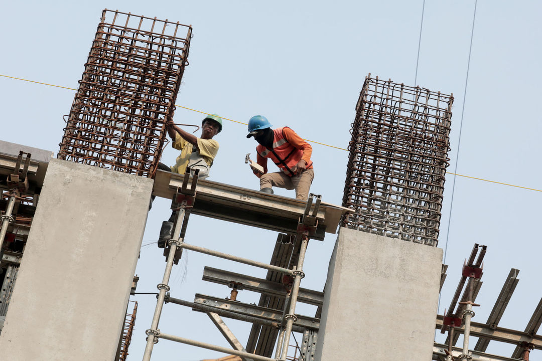 Pekerja beraktivitas di proyek pembangunan rumah susun.