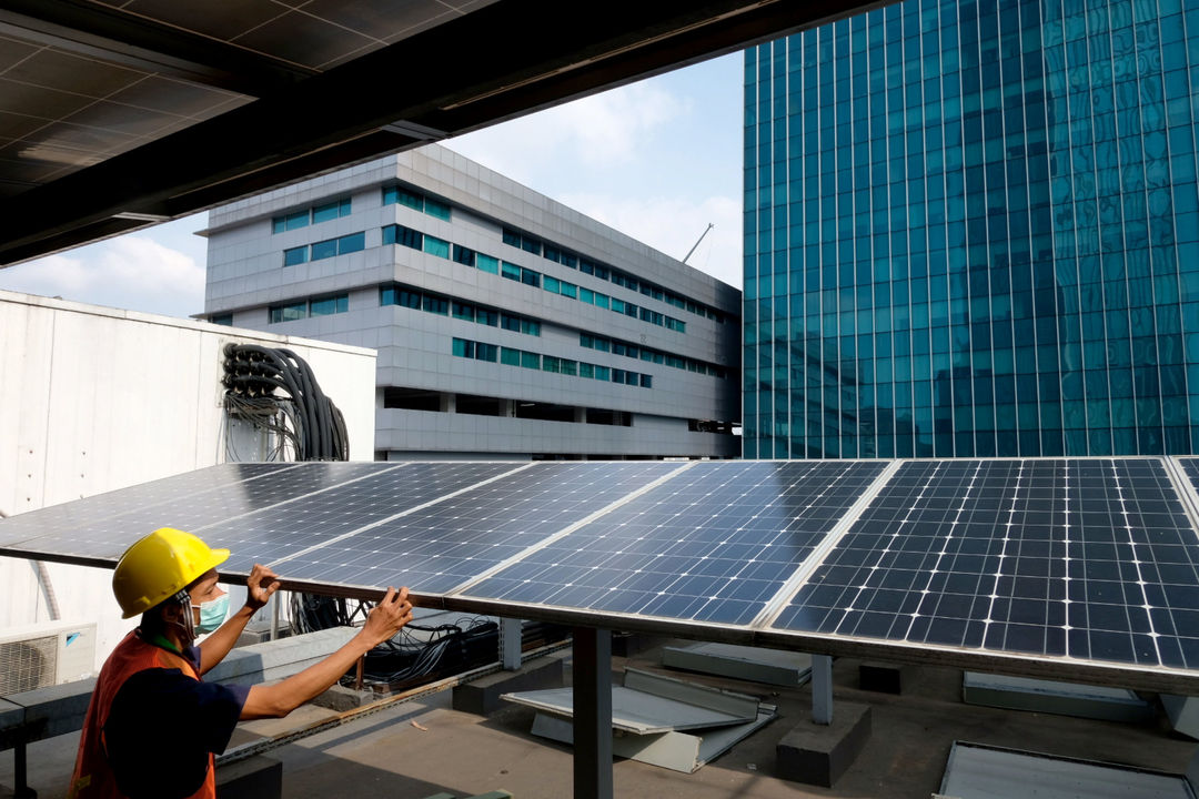 Pekerja memeriksa intalasi panel surya di gedung Dirjen Ketenagalistrikan Kementerian ESDM, di Jalan Rasuna Said, Kuningan, Jakarta, Senin, 27 September 2021. Foto: Ismail Pohan/TrenAsia