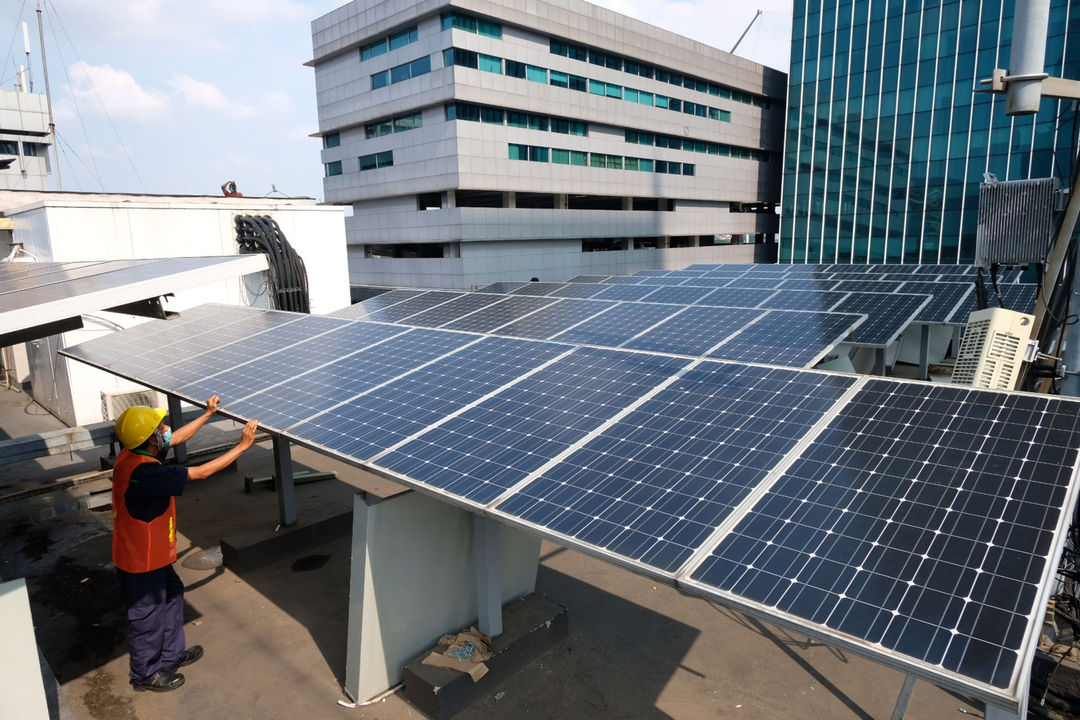 Pekerja memeriksa intalasi panel surya di gedung Dirjen Ketenagalistrikan Kementerian ESDM, di Jalan Rasuna Said, Kuningan, Jakarta, Senin, 27 September 2021. Foto: Ismail Pohan/TrenAsia