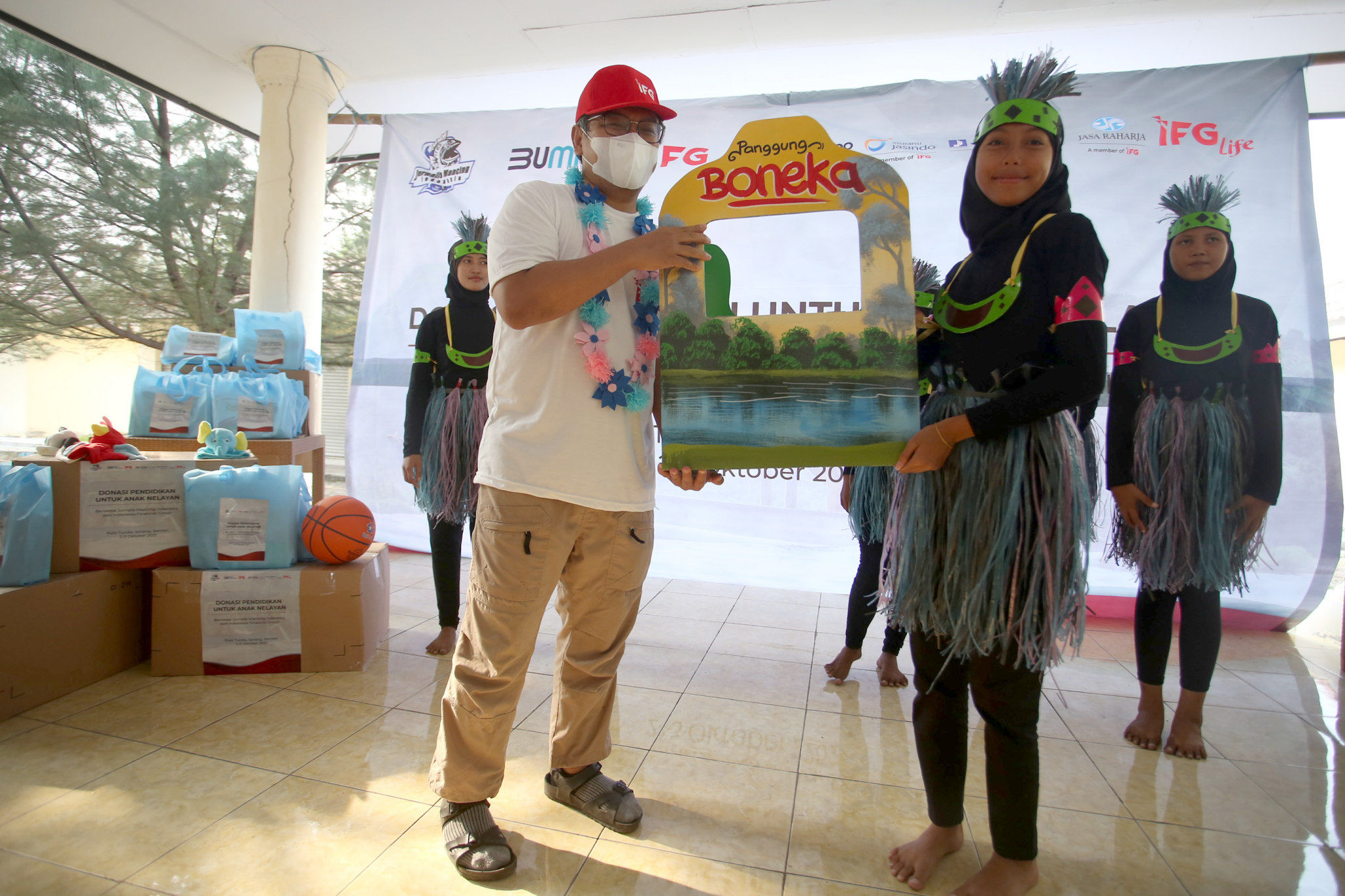 Sekretaris Perusahaan Indonesia Financial Group (IFG), Beko Setiawan memberikan simbolis bantuan alat permainan kepada anak nelayan di Pulau Tunda, Banten. Foto: Istimewa/Dok. JMI