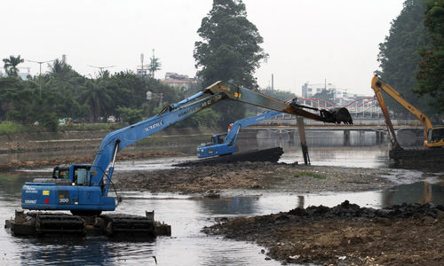 Nampak sejumlah alat berat tengah melakukan pengerukan di Kali Mookevart , Jl Daan Mogot Jakarta Barat, Senin 4 Oktober 2021. Foto : Panji Asmoro/TrenAsia