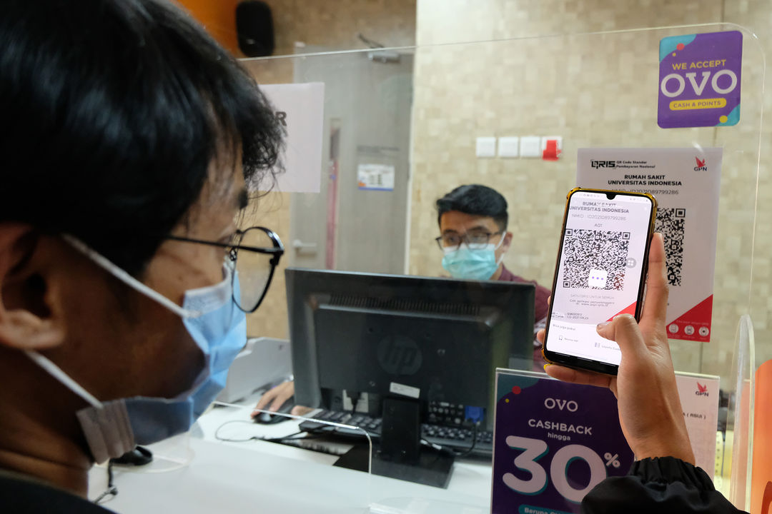 Keluarga pasien melakukan pembayaran melalui pemindaian QRIS platform dompet digital OVO di kasir Rumah Sakit Universitas Indonesia (RSUI), Depok, Jawa Barat, Rabu, 13 Oktober 2021. Foto: Ismail Pohan/TrenAsia