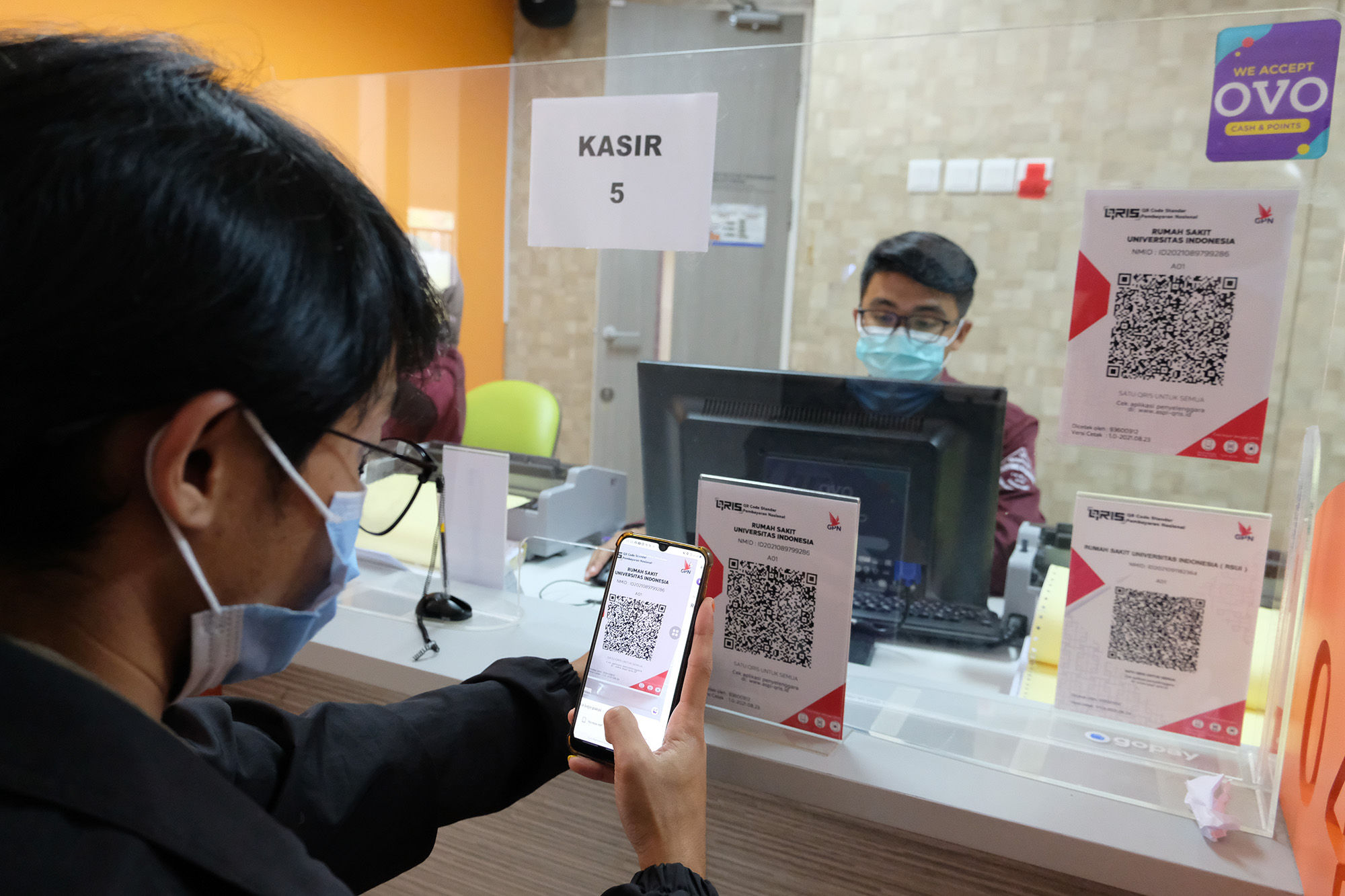 Keluarga pasien melakukan pembayaran melalui pemindaian QRIS platform dompet digital OVO di kasir Rumah Sakit Universitas Indonesia (RSUI), Depok, Jawa Barat, Rabu, 13 Oktober 2021. Foto: Ismail Pohan/TrenAsia