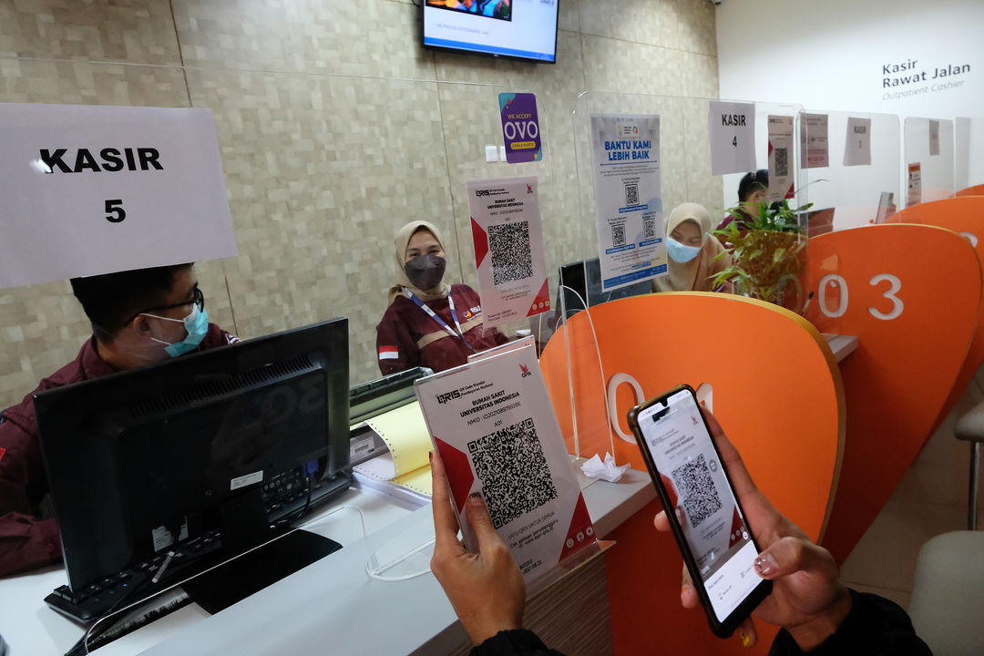 Keluarga pasien melakukan pembayaran melalui pemindaian QRIS platform dompet digital OVO di kasir Rumah Sakit Universitas Indonesia (RSUI), Depok, Jawa Barat, Rabu, 13 Oktober 2021. Foto: Ismail Pohan/TrenAsia