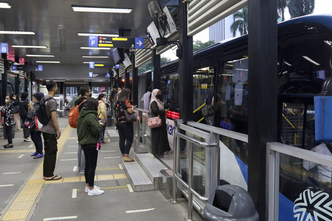 Sejumlah penumpang menunggu kedatangan armada bus TransJakarta di halte kawasan Sudirman, Jakarta, Jum'at, 22 Oktober 2021. Foto: Ismail Pohan/TrenAsia