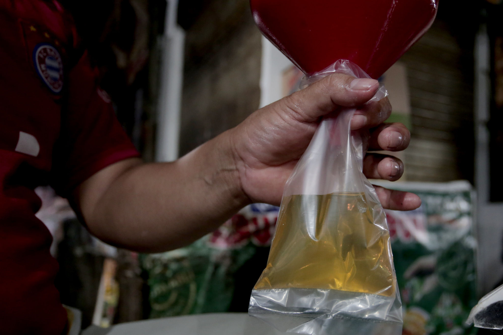 Pedagang mengemas minyak curah di salah satu kios pasar tradisional di Jakarta, Kamis, 4 November 2021. Foto: Ismail Pohan/TrenAsia