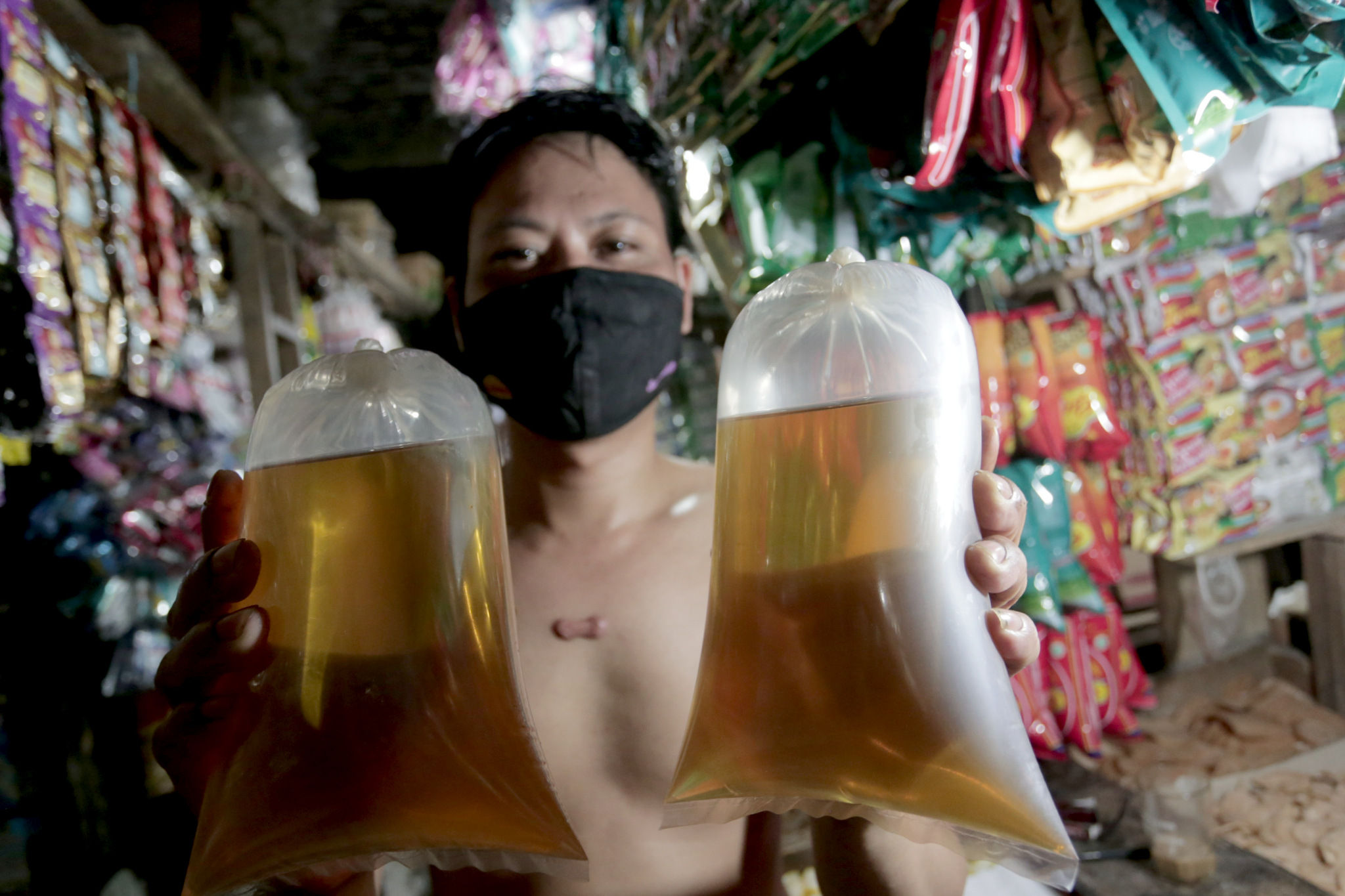 Pedagang mengemas minyak curah di salah satu kios pasar tradisional di Jakarta, Kamis, 4 November 2021. Foto: Ismail Pohan/TrenAsia