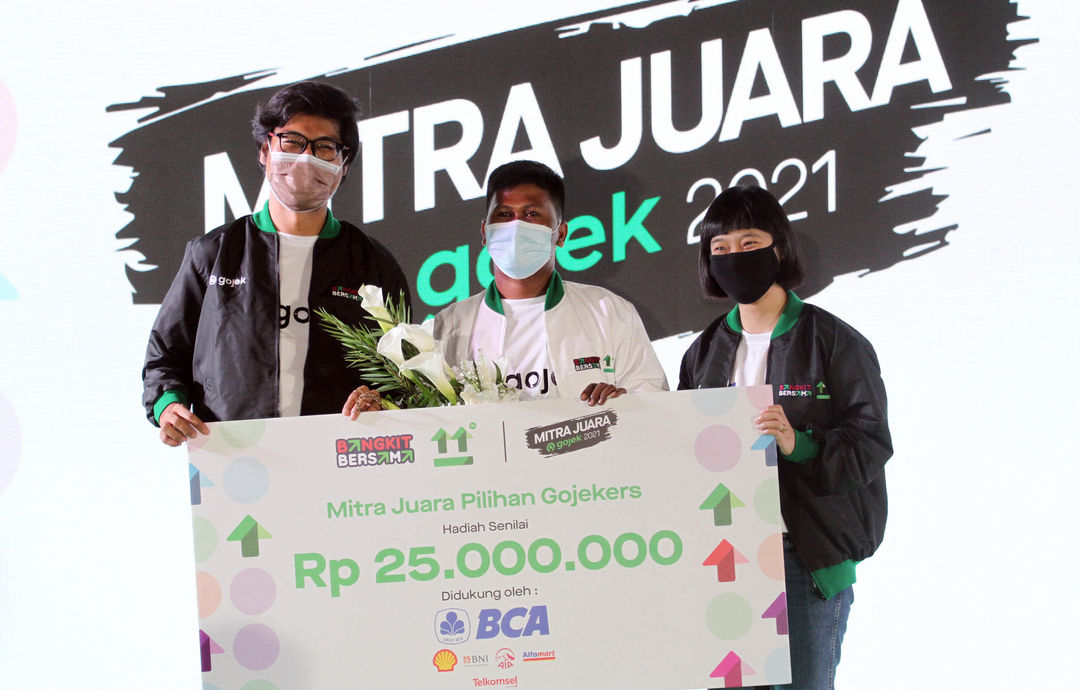 Jubeironi, Mitra Driver GoRide mendapatkan penghargaan Mitra Juara Gojek Pilihan Gojekers didampingi oleh Chief Transport Officer Gojek - Raditya Wibowo (kiri) dan Chief Food Officer Gojek- Catherine Hindra Sutjahyo (kanan). Penghargaan ini diberikan di acara Ngobrol Bareng Gojek sekaligus Apresiasi Mitra Juara Gojek di Jakarta, Jumat 5 November 2021. Foto : Panji Asmoro/TrenAsia