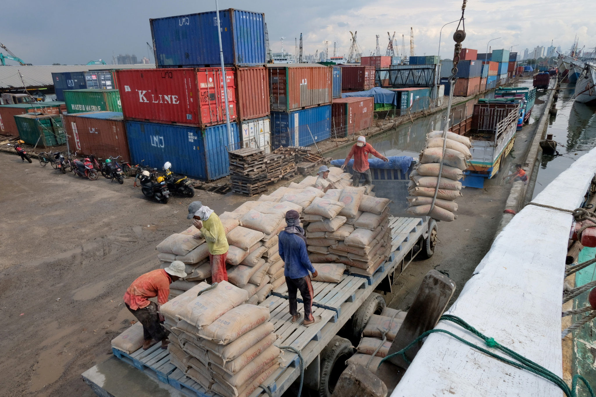 Aktivitas pekerja melakukan bongkar muat barang dari kendaraan truk ke kapal logistik yang bersandar di dermaga pelabuhan Sunda Kelapa, Jakarta, Selasa, 16 November 2021. Foto: Ismail Pohan/TrenAsia