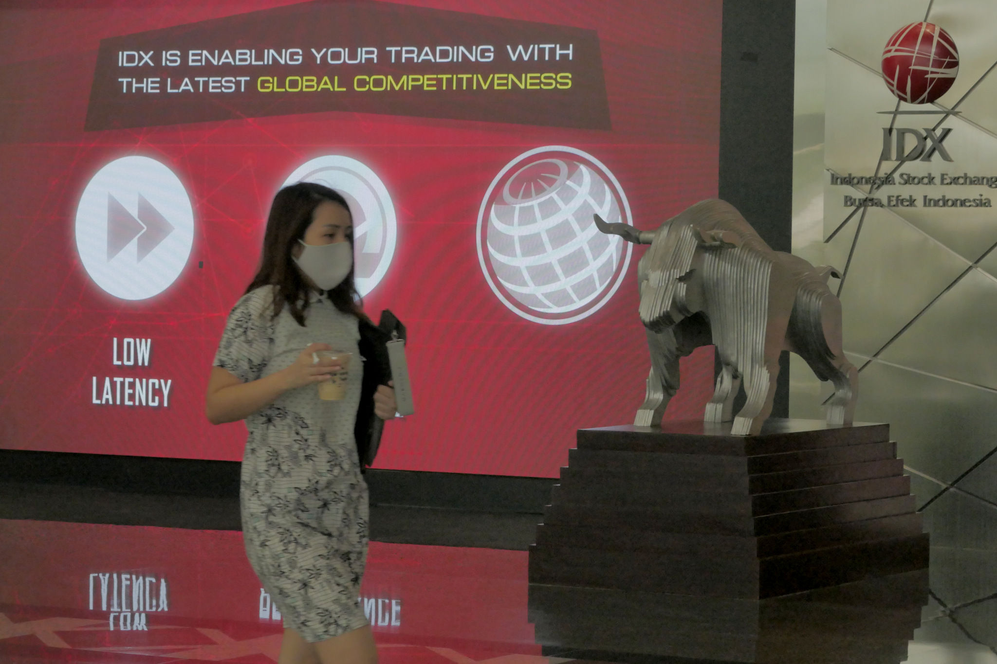 Karyawan melintas dengan latar layar pergerakan indeks harga saham gabungan (IHSG) di Gedung Bursa Efek Indonesia (BEI) Jakarta, Senin, 22 November 2021. Foto: Ismail Pohan/TrenAsia