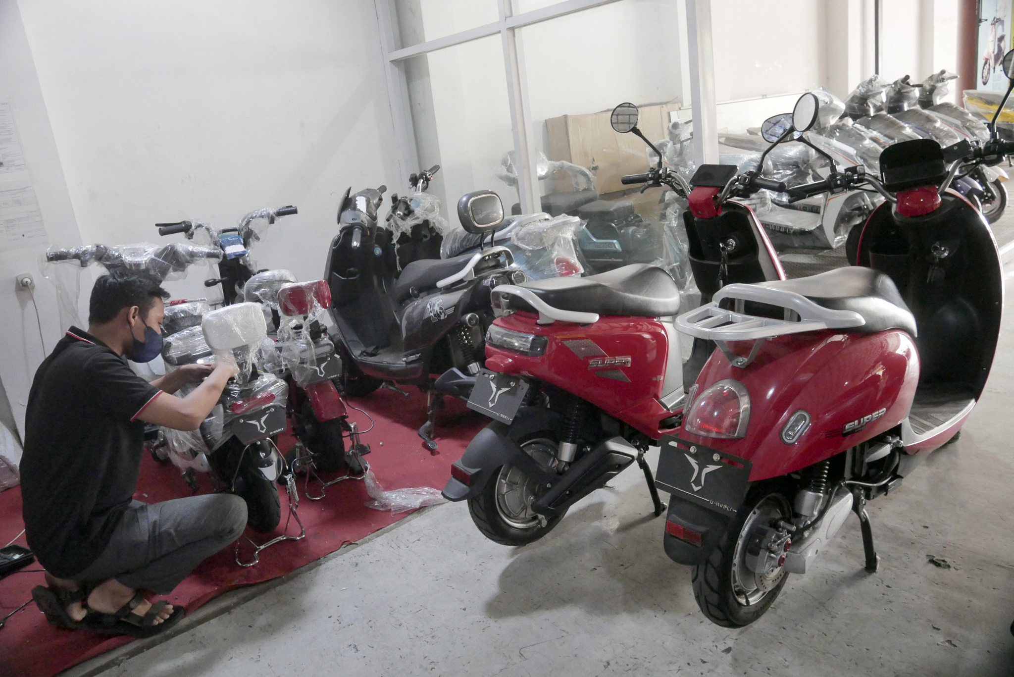 Mekanik memeriksa unit di showroom penjualan sepeda motor listrik Uwinfly dikawasan Otista, Jakarta, Rabu, 24 November 2021. Foto: Ismail Pohan/TrenAsia