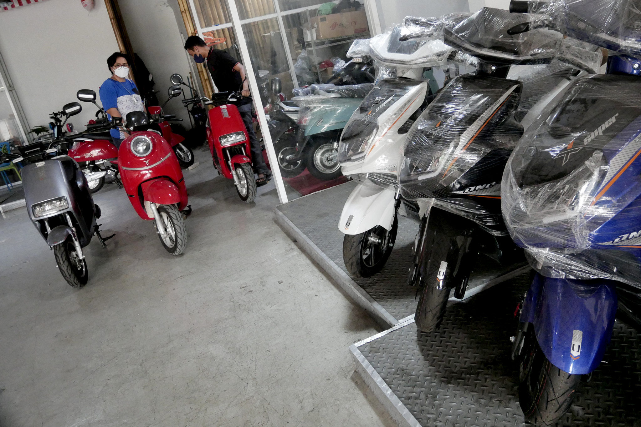 Karyawan melayani calon pembeli di showroom penjualan sepeda motor listrik Uwinfly dikawasan Otista, Jakarta, Rabu, 24 November 2021. Foto: Ismail Pohan/TrenAsia