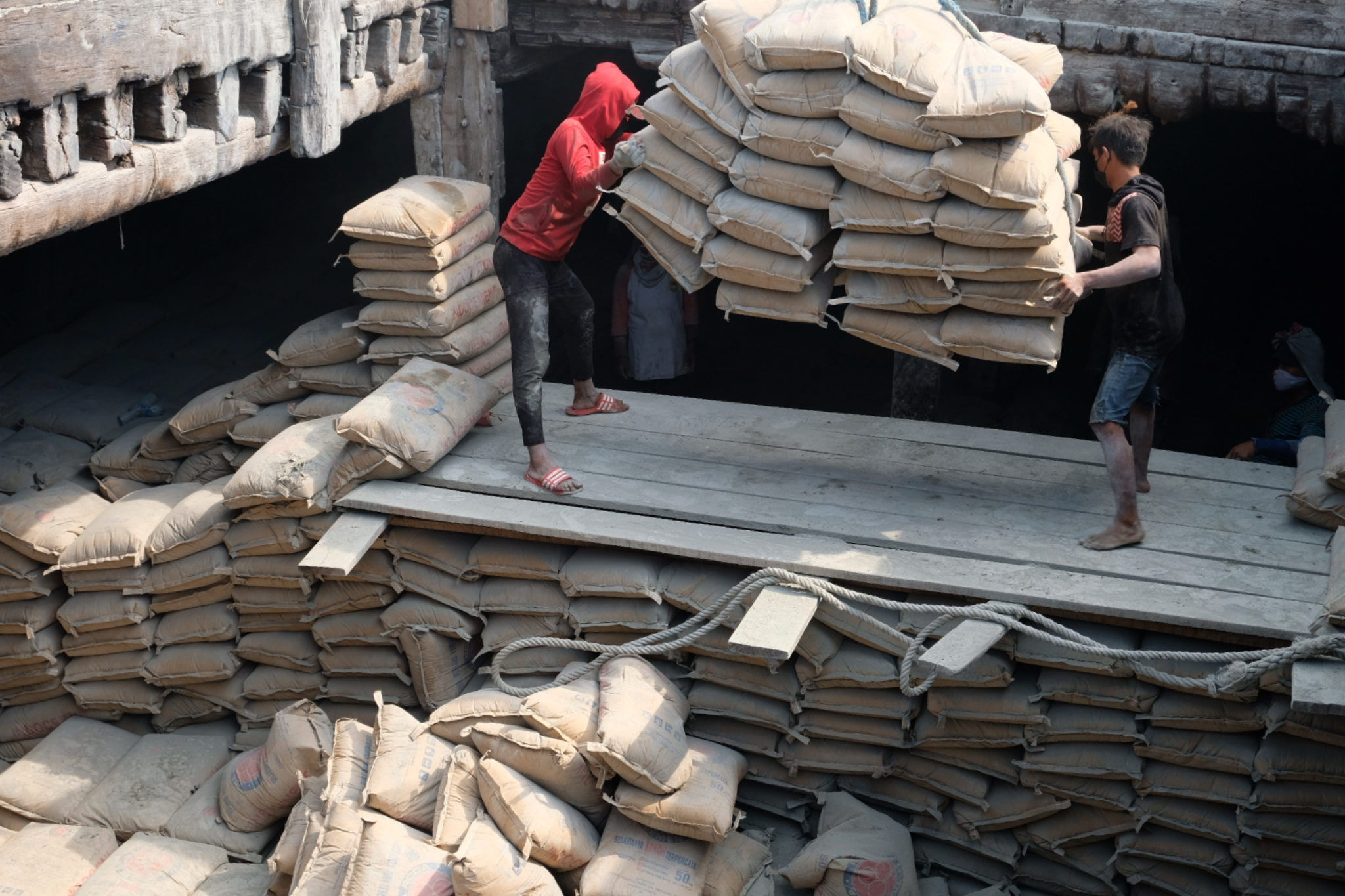 Pekerja melakukan bongkar muat semen dengan kapal angkut barang di dermaga pelabuhan Sunda Kelapa, Jakarta Utara. Foto: Ismail Pohan/TrenAsia