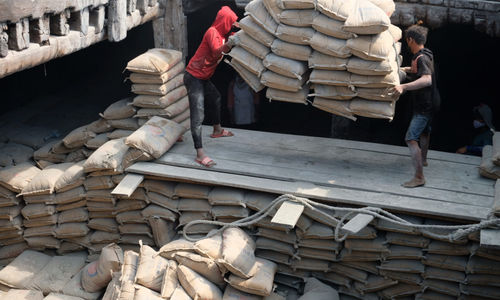 Pekerja melakukan bongkar muat semen dengan kapal angkut barang di dermaga pelabuhan Sunda Kelapa, Jakarta Utara. Foto: Ismail Pohan/TrenAsia