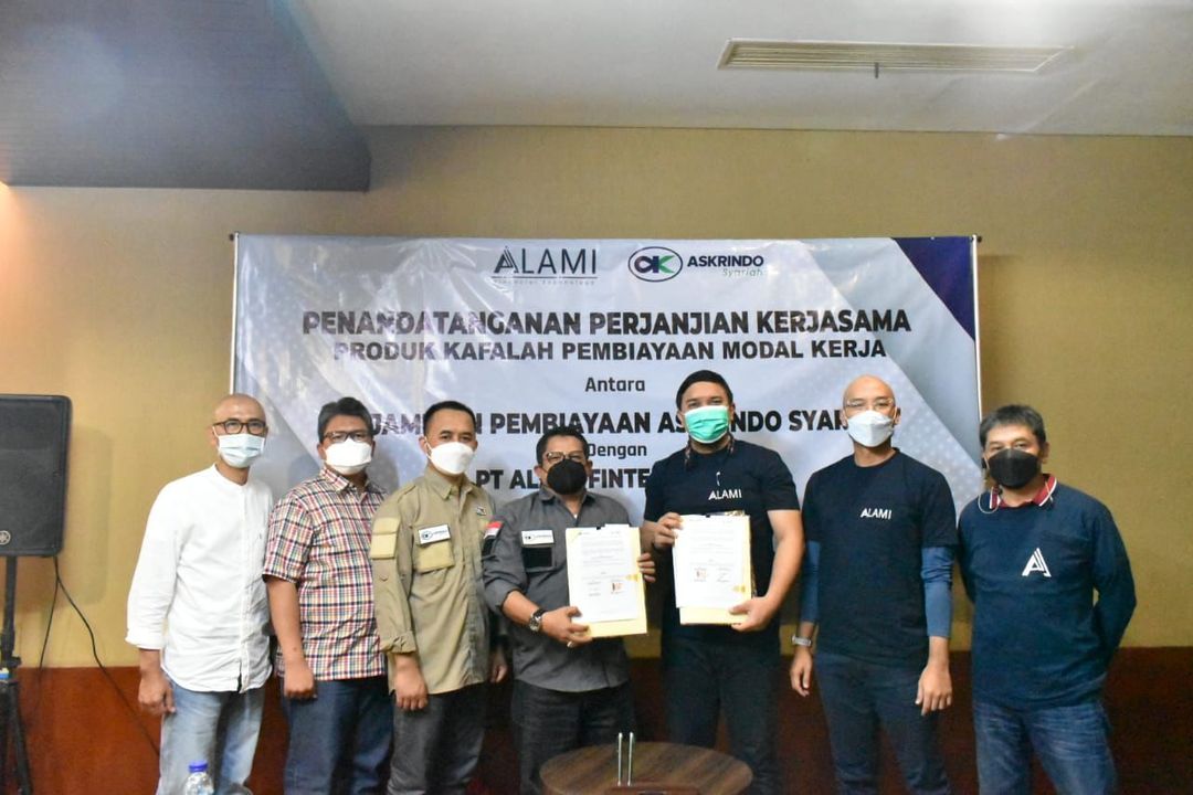 Direktur Pemasaran PT Jaminan Pembiayaan Askrindo Syariahatau Askrindo Syariah, Supardi Najamuddin (tengah) dan Direktur Bisnis PT Alami Fintek Sharia atau Fintech Alami, Bembi Juniar (ketiga kanan) melakukan prosesi tanda tangan perjanjian kerjasama Kafalah Pembiayaan Modal Kerja di Jakarta, Jumat (10/12/2021).