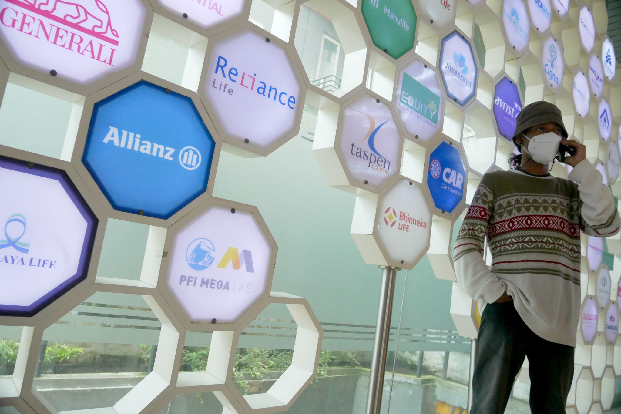 Karyawan beraktifitas di dekat logo berbagai asuransi jiwa di kantor Asosiasi Asuransi Jiwa Indonesia (AAJI) di Jakarta, Senin, 13 Desember 2021 . Foto: Ismail Pohan/TrenAsia