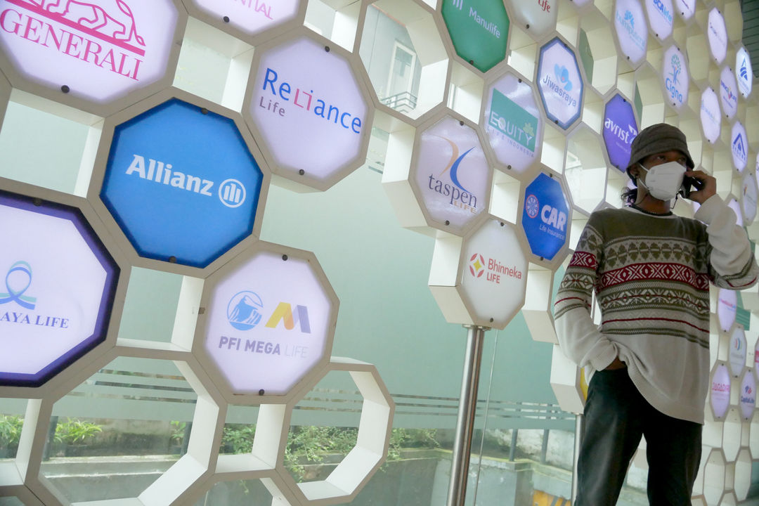 Karyawan beraktifitas di dekat logo berbagai asuransi jiwa di kantor Asosiasi Asuransi Jiwa Indonesia (AAJI) di Jakarta, Senin, 13 Desember 2021 . Foto: Ismail Pohan/TrenAsia