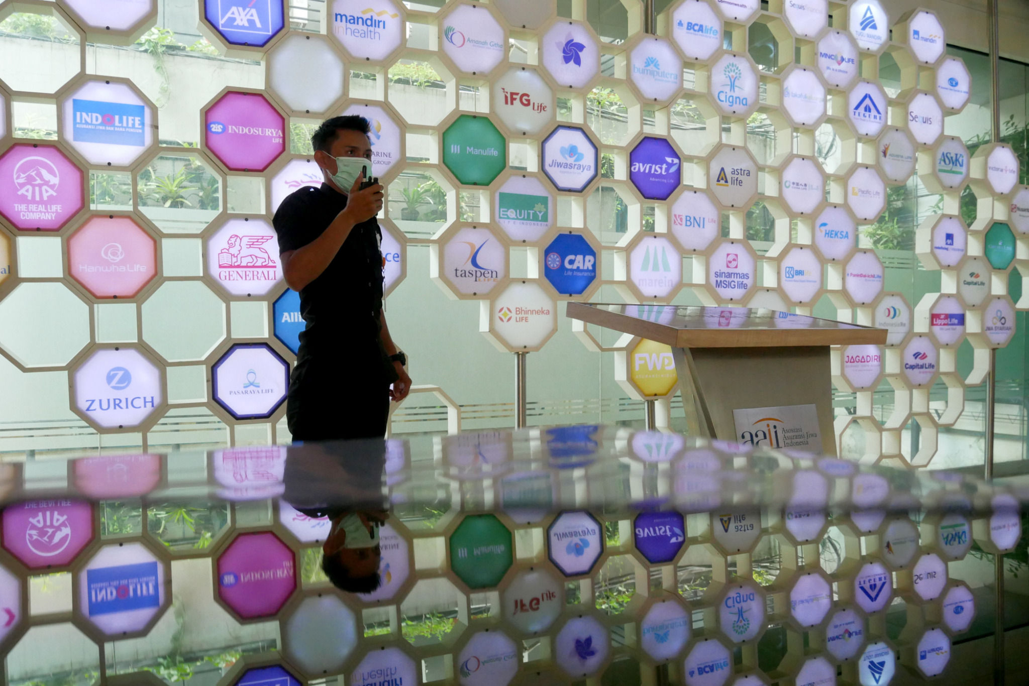 Karyawan beraktifitas di dekat logo berbagai asuransi jiwa di kantor Asosiasi Asuransi Jiwa Indonesia (AAJI) di Jakarta, Senin, 13 Desember 2021 . Foto: Ismail Pohan/TrenAsia