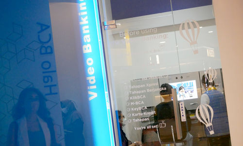 Karyawati membantu nasabah menggunakan layanan video banking di kantor cabang Bank BCA, Gandaria City, Jakarta, Kamis, 16 Desember 2021. Foto: Ismail Pohan/TrenAsia