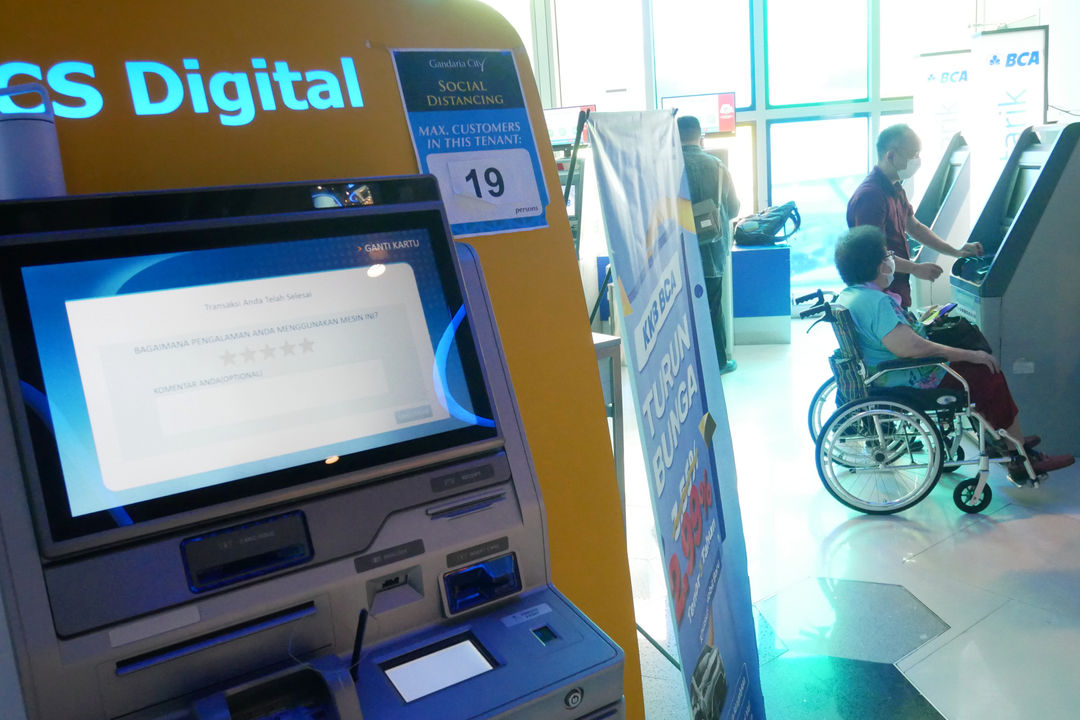 Nasabah melakukan transaksi menggunakan mesin ATM di kantor cabang Bank BCA, Gandaria City, Jakarta, Kamis, 16 Desember 2021. Foto: Ismail Pohan/TrenAsia