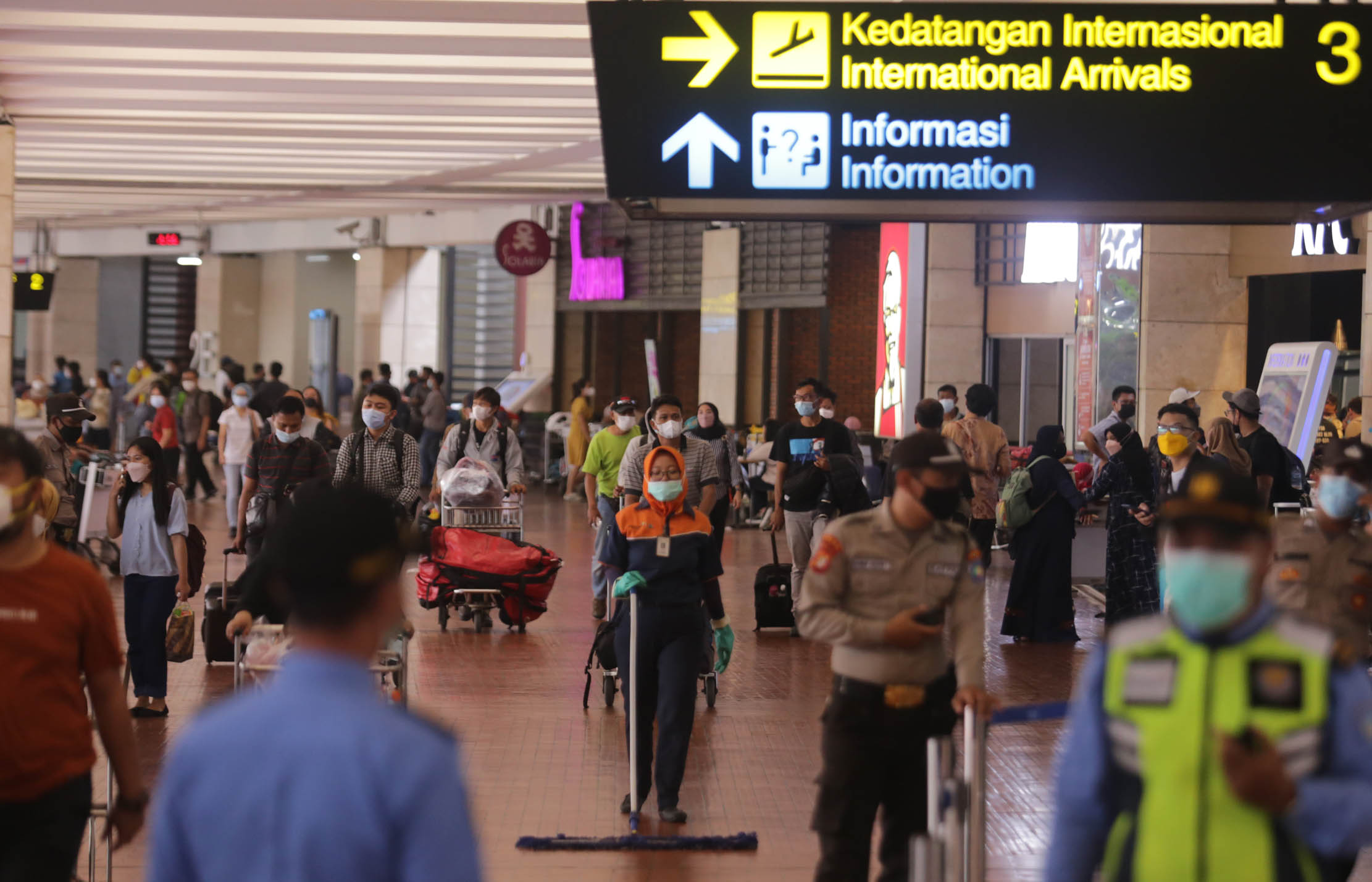 Sejumlah penumpang pesawat berjalan di area Terminal 2F Internasional Bandara Soekarno Hatta. PT Angkasa Pura II mengoperasikan kembali Terminal 2F untuk kedatangan penumpang internasional guna mengantisipasi penumpukan penumpang setelah sebelumnya hanya Terminal 3 yang digunakan sebagai lokasi ketibaan internasional. Jumat 17 Desember 2021. Foto : Panji Asmoro/TrenAsia