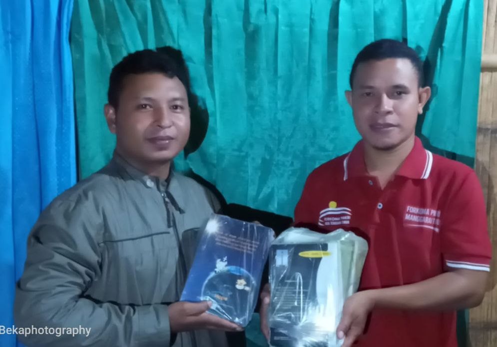 Gonsa Poseng saat menyerahkan buku bantuan kepada Kepala Sekolah SDI Ndangi, Sifrinus Salmi Naur.