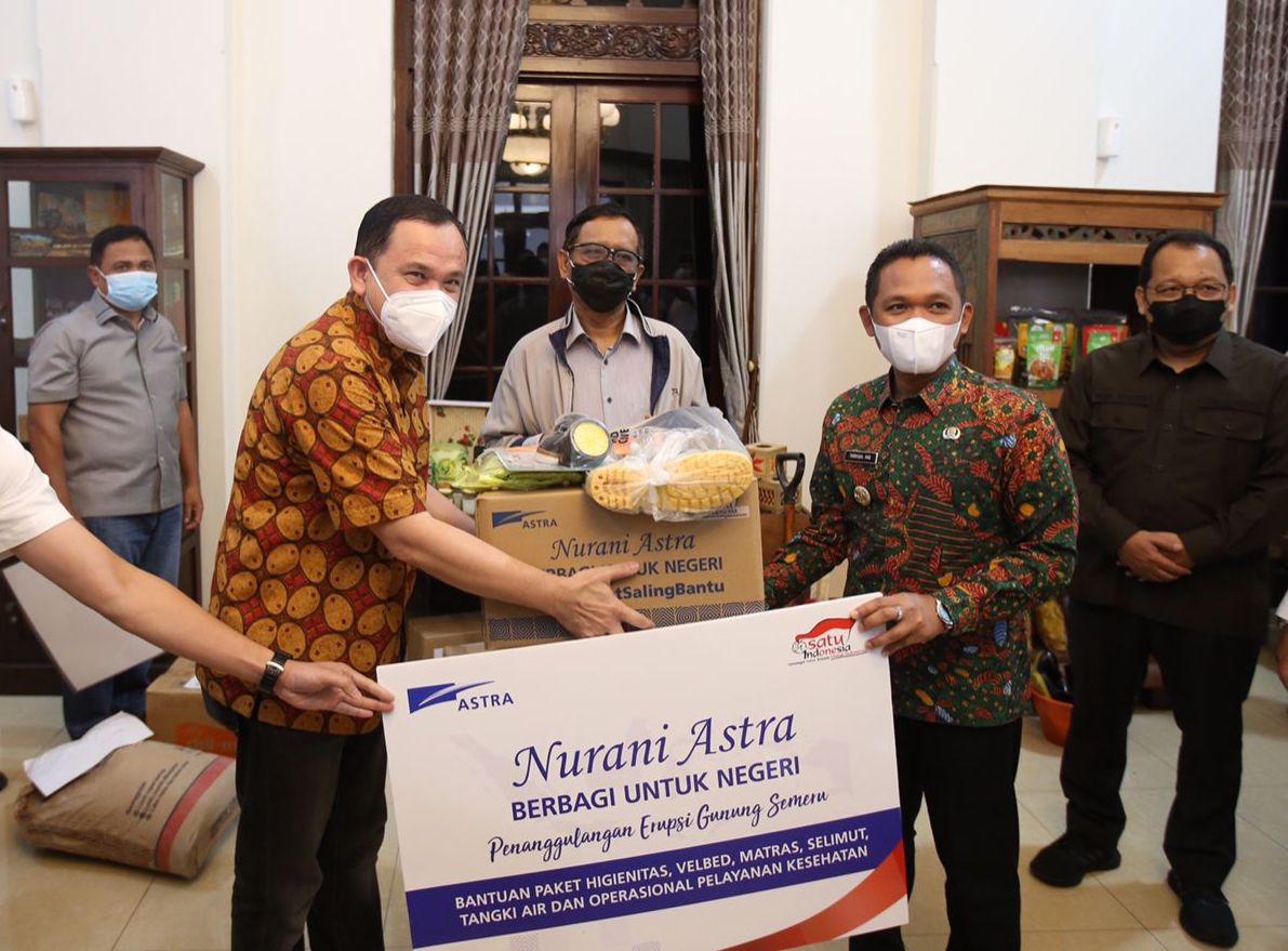 Menteri Koordinator Bidang Politik, Hukum, dan Keamanan Republik Indonesia Mahfud MD (tengah) menyaksikan penyerahan bantuan untuk korban bencana alam erupsi Gunung Semeru dari Astra yang diwakili oleh Chief of Corporate Affairs Astra Riza Deliansyah (kiri) kepada Bupati Lumajang Thoriqul Haq (kanan) Jumat (17/12/2021) di pendopo Kabupaten Lumajang.